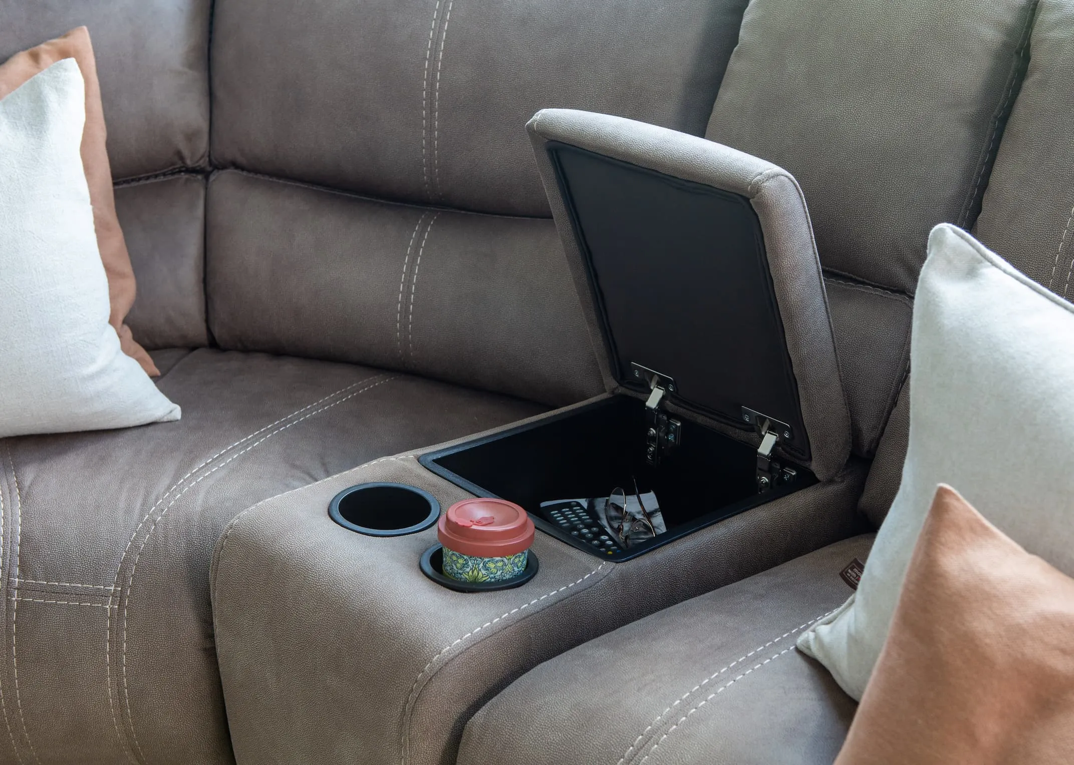 A lifestyle imange of the Baxter Large corner modular sofa with a closeup on the drinks holder unit.