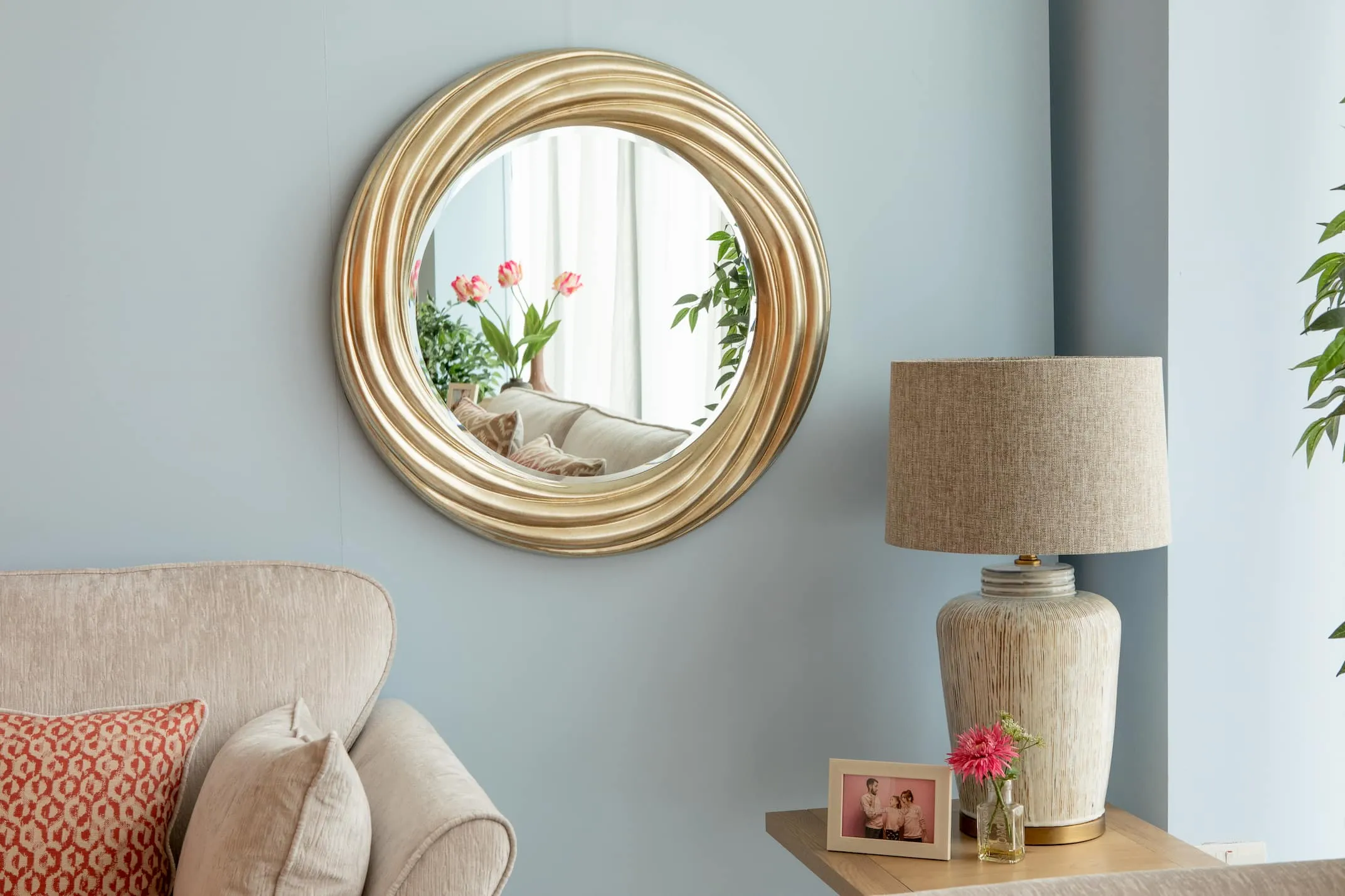 A lifestyle image of the Gemma Gold Mirror on a wall above the Coolmore Sofa & Sonoma furniture.