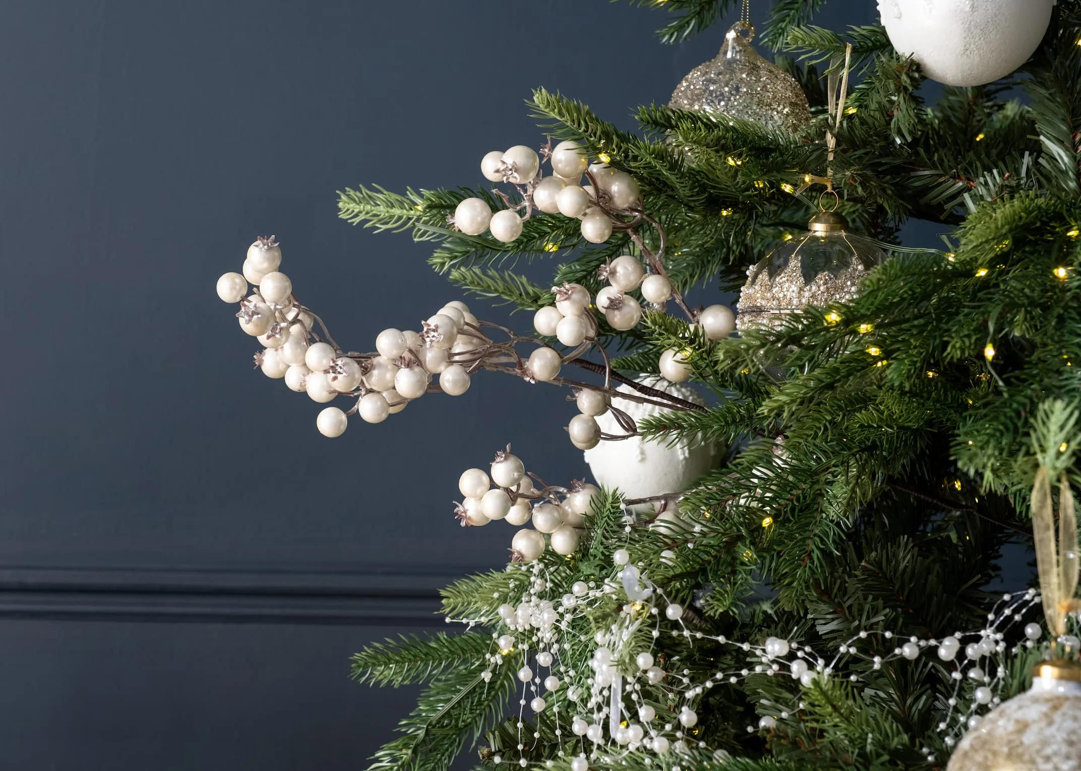 A lifestyle image of the Rockefeller tree with a selection of baubels and the pearl pick