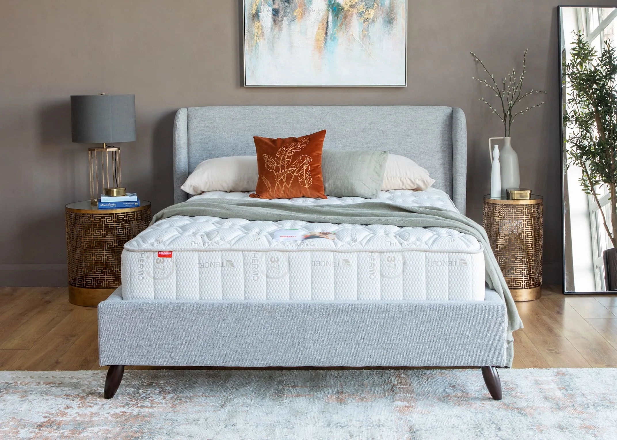 A lifestyle image of the Marcello Grey fabric bed with rosemary mattress and Greek side tables.