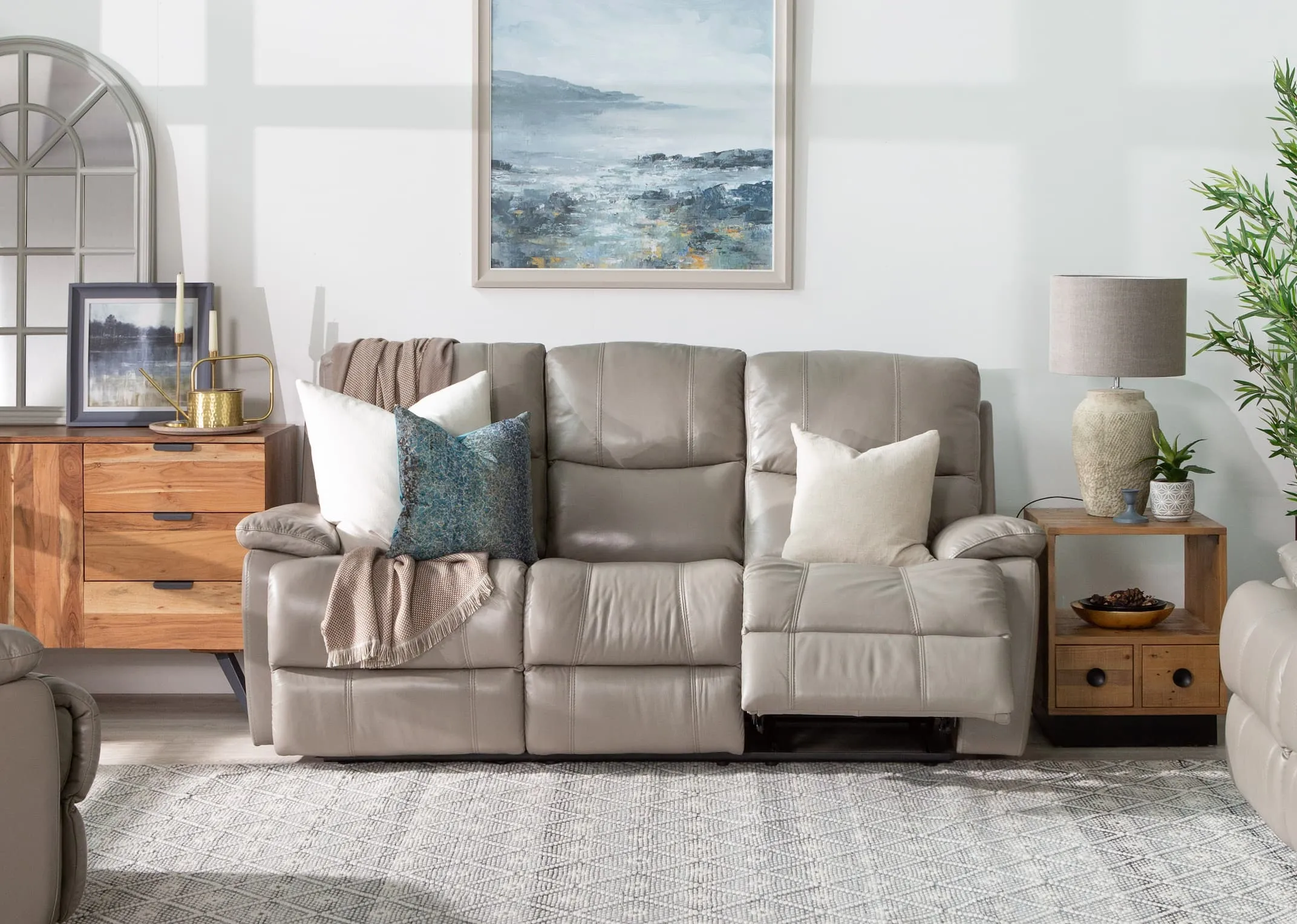 A lifestyle image of the Groove Grey leather 3 seater power recliner with San francisco lamp table & malta sideboard.