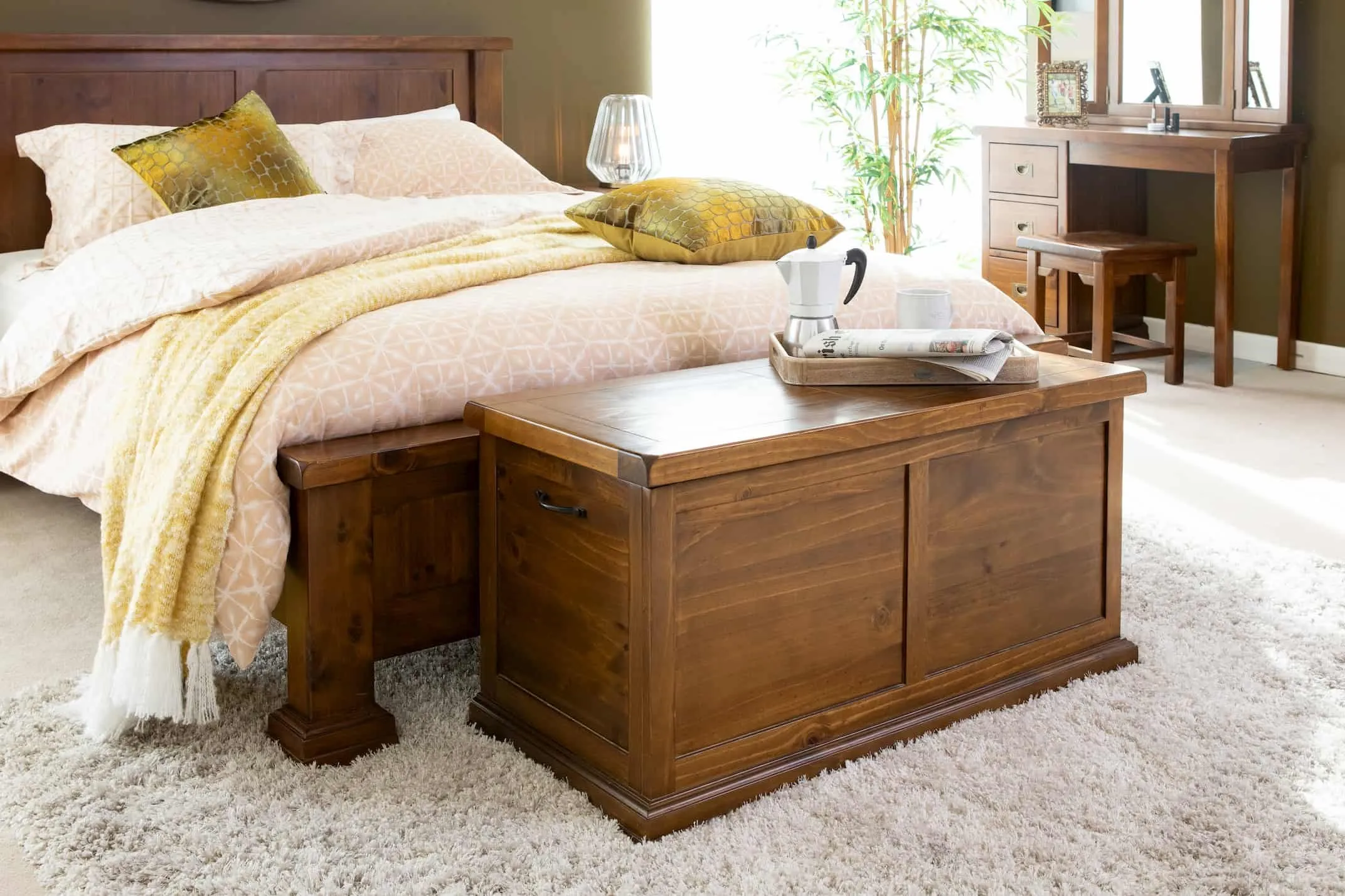 A lifestyle image of the Aisling Blanket box at the foot of the bedframe with matching furniture.