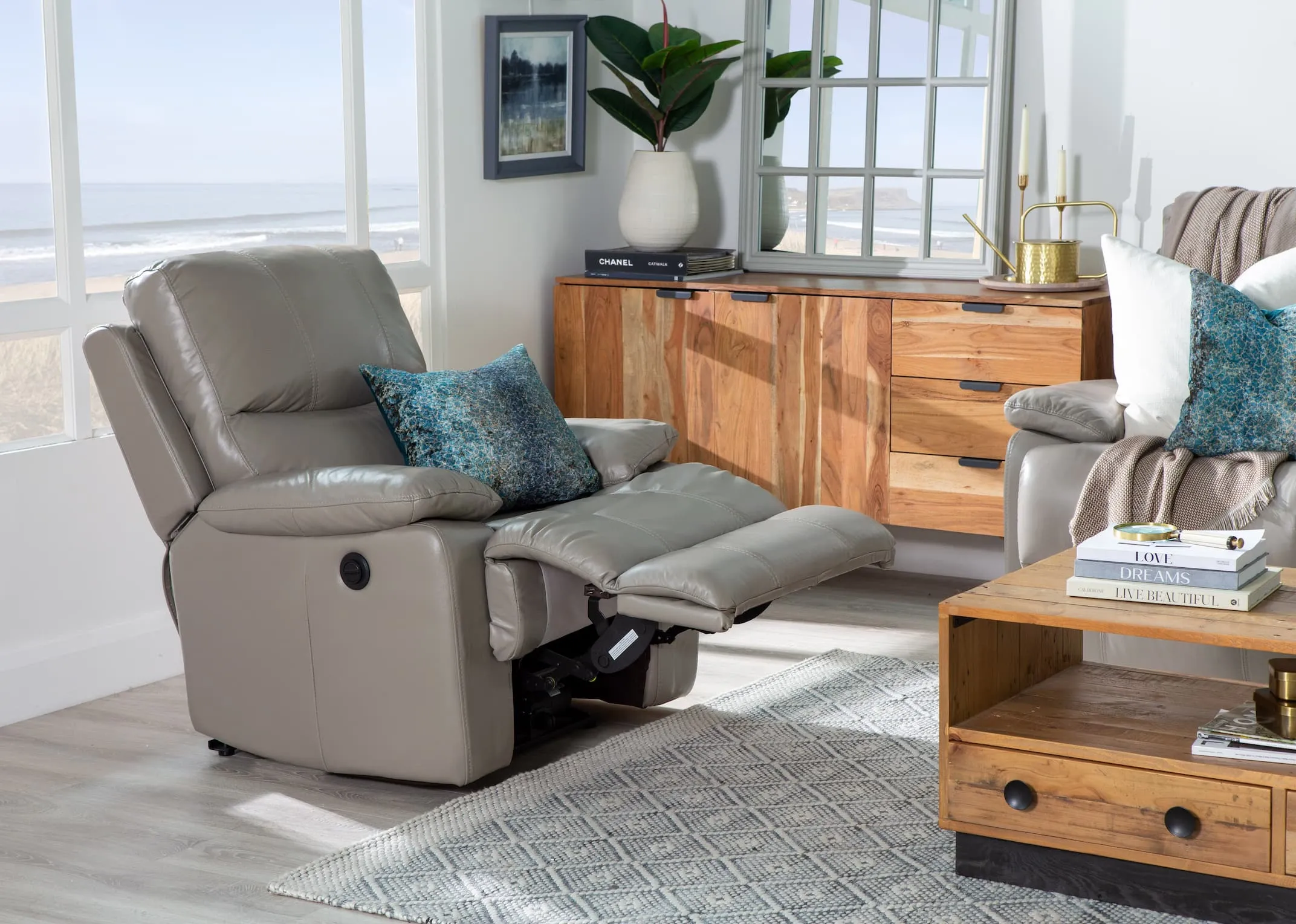 A lifestyle image of the Groove grey leather recliner with San Fran living in power reclining mode.