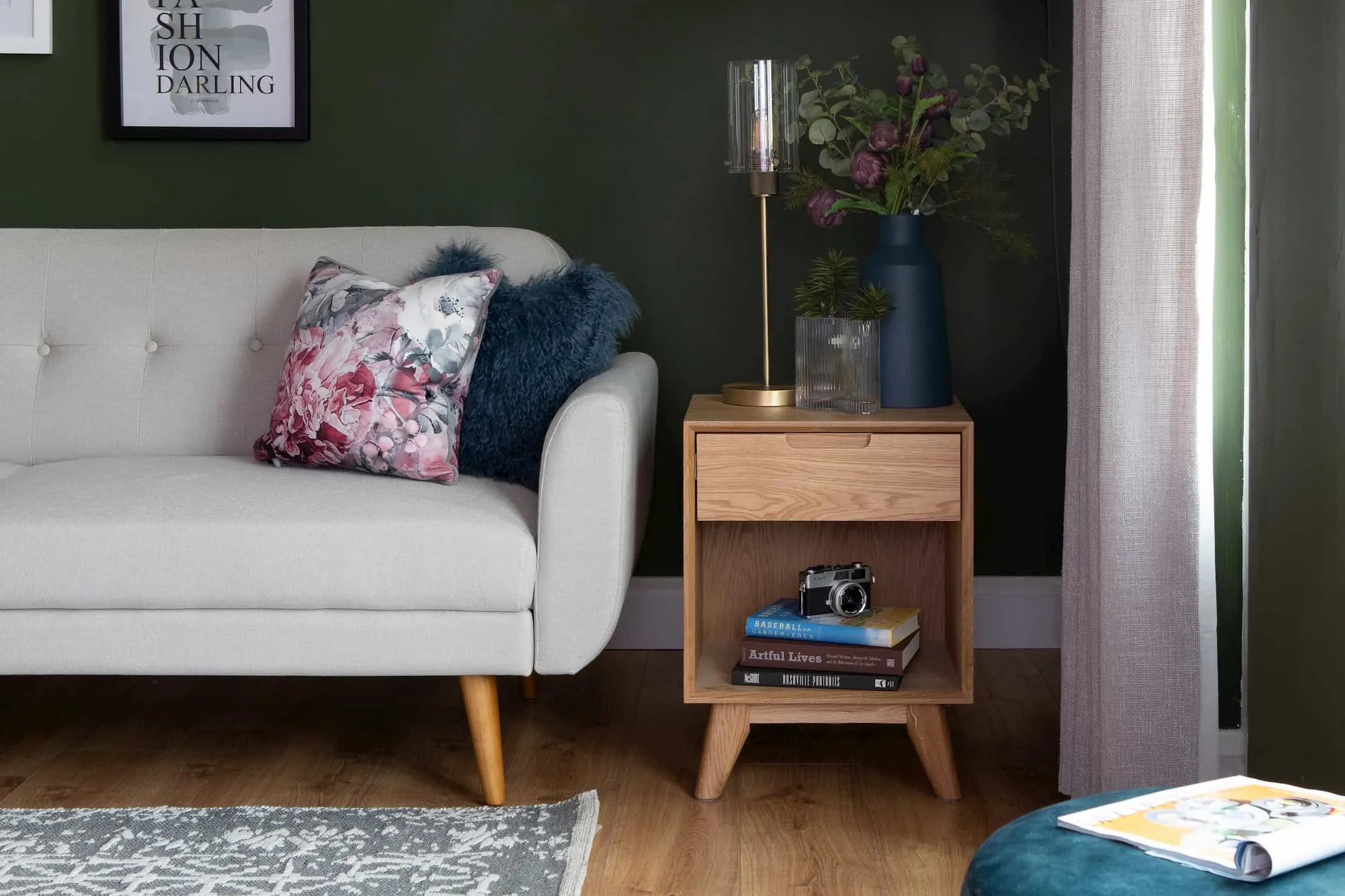 A lifestyle image of the brass standing Karina table lamp with the Rho locker & Metro Sofa Bed