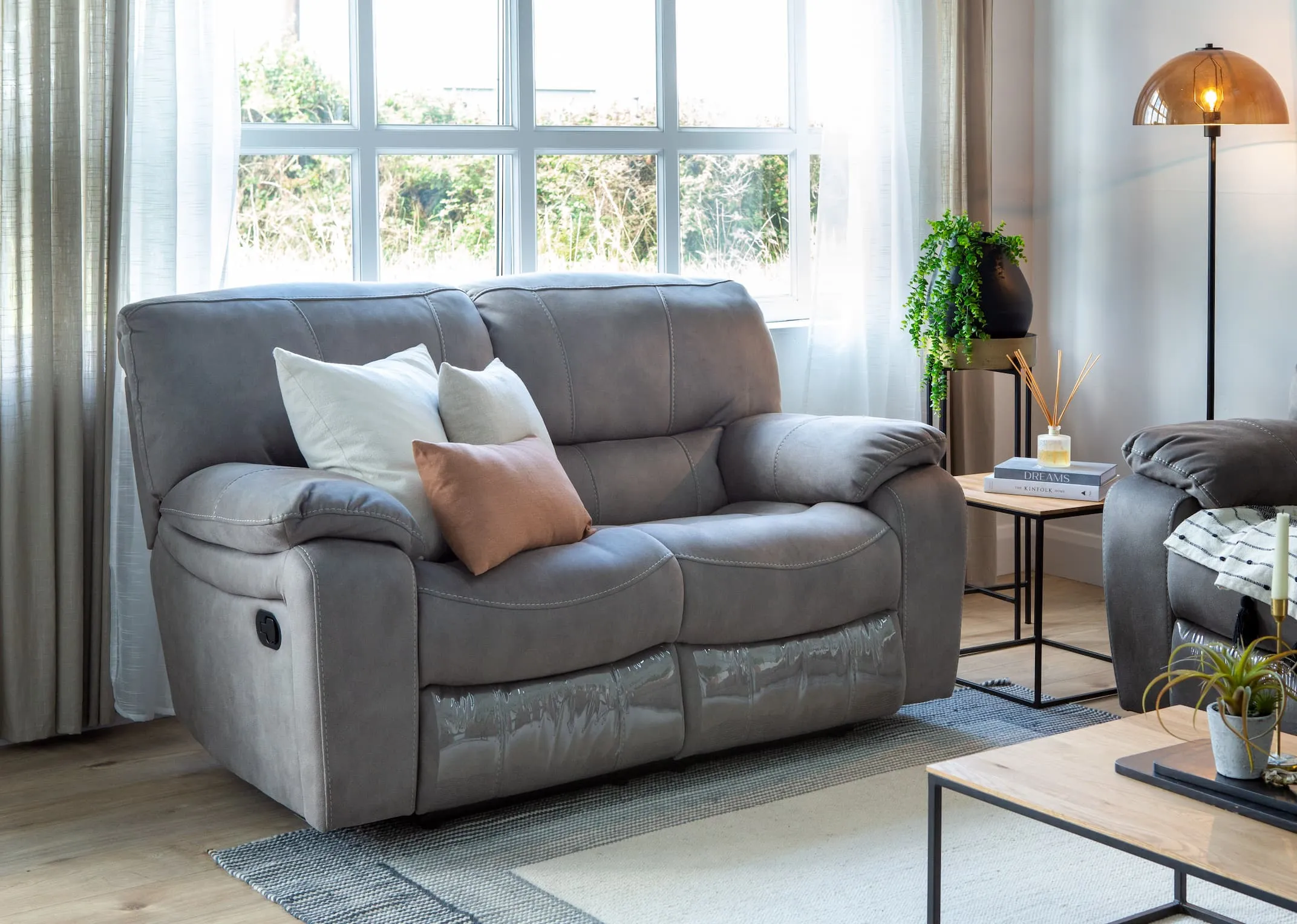A lifestyle image of the Bradford 2 Seater sofa reclined with the Aston tables.