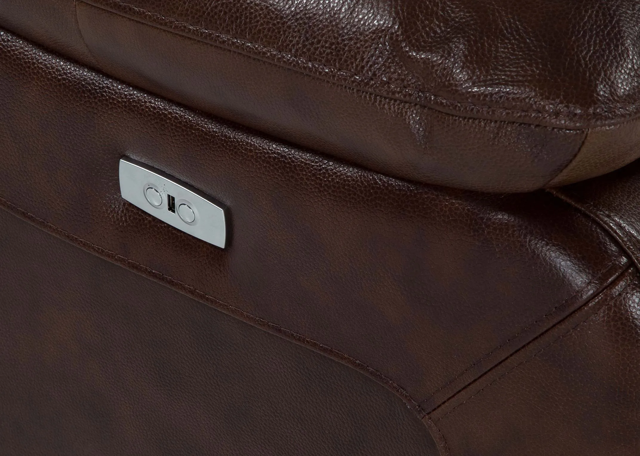 A close up of the power reclining button on the Supremebrown leather 2 seater power reclining sofa.
