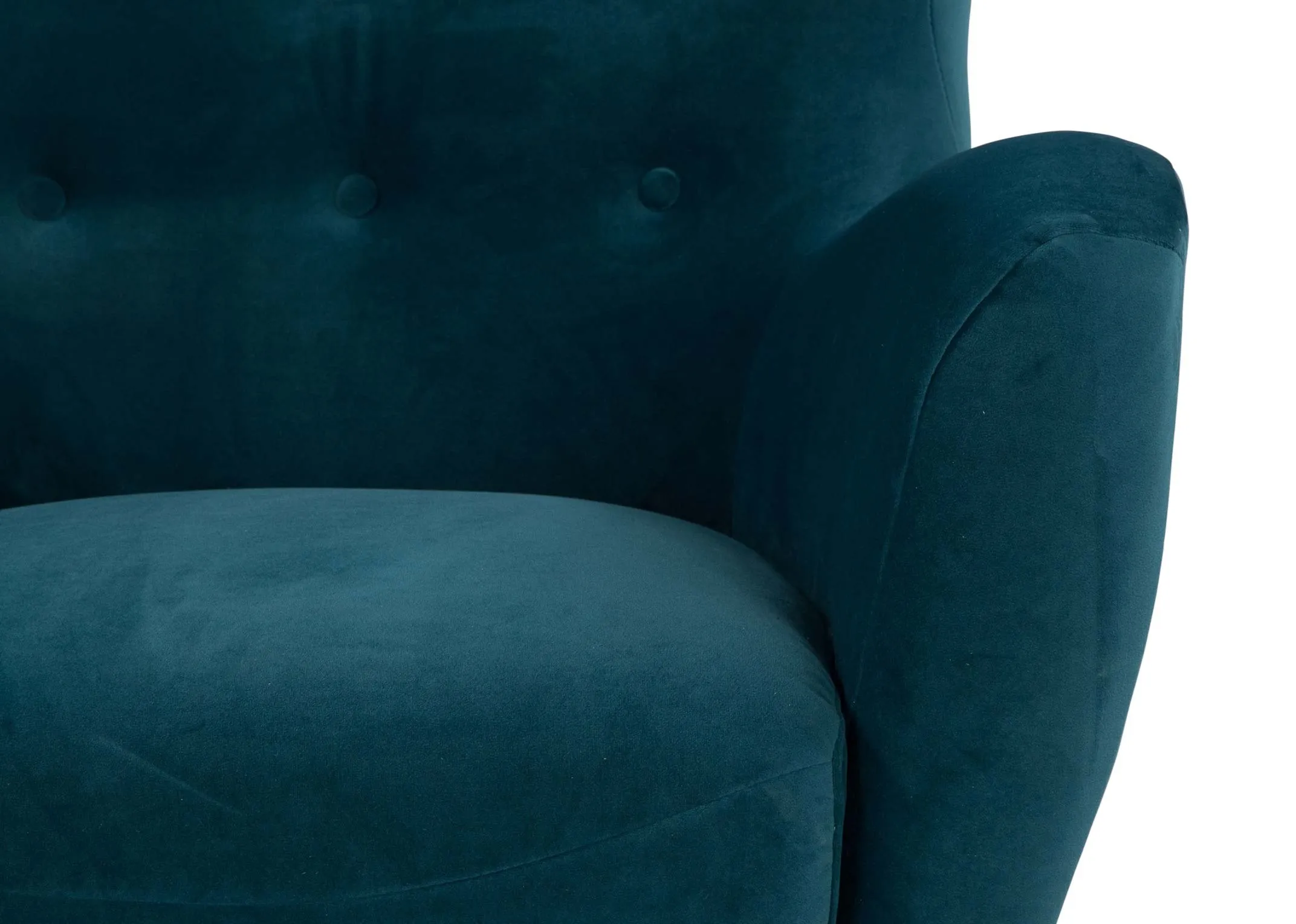A close up of the tufted button upholstery and armrest on the Bronx armchair in teal velvet.