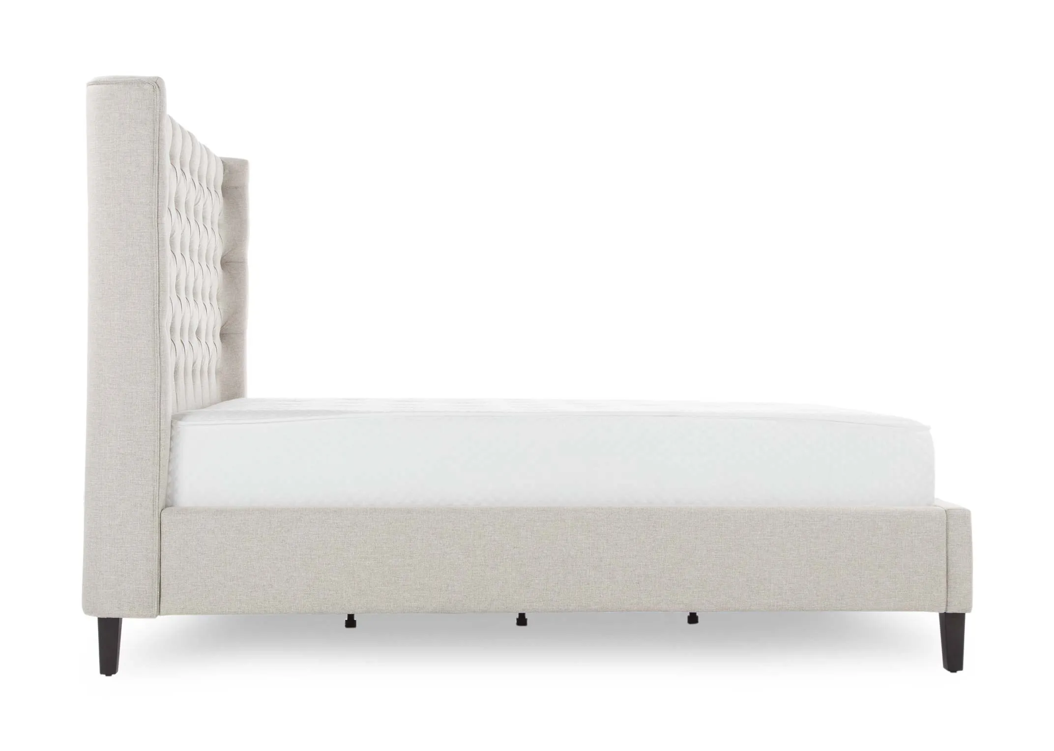 A view from the side looking at the beige fabric 6 ft Chelsea bedframe