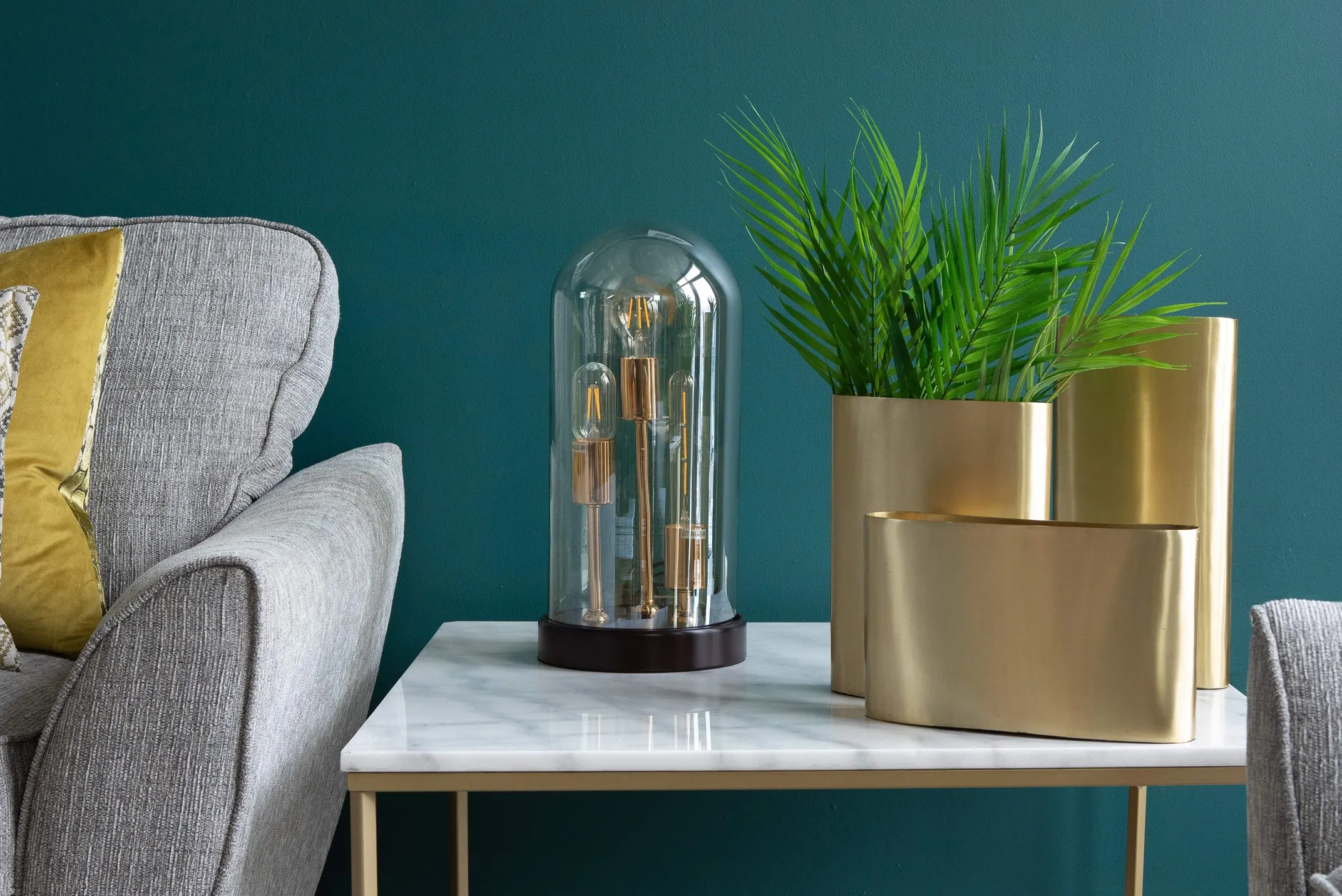 A lifestyle image of the globe Wilks table lamp featuring the Aria sofa and Alisma table