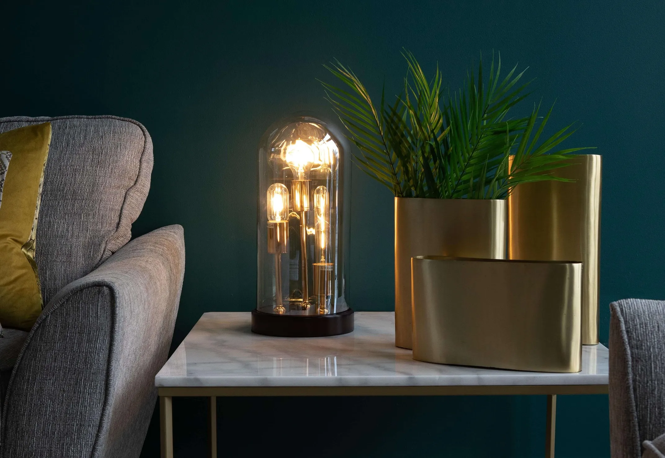 A lifestyle image of the globe Wilks table lamp with the lights on