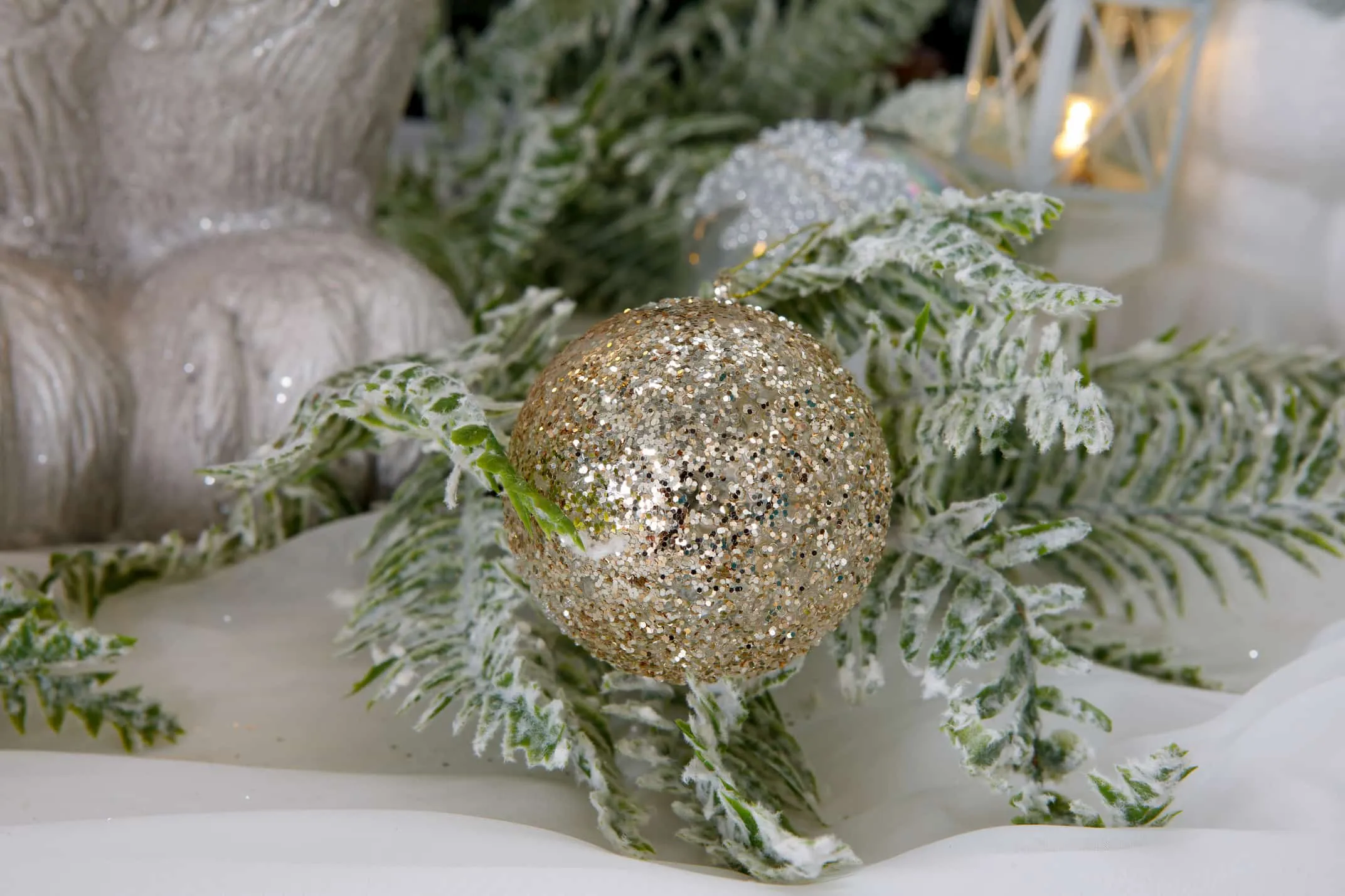 A lifestyle image of the Gold Glitter Bauble on a Christmas tree from EZ Living Furniture.