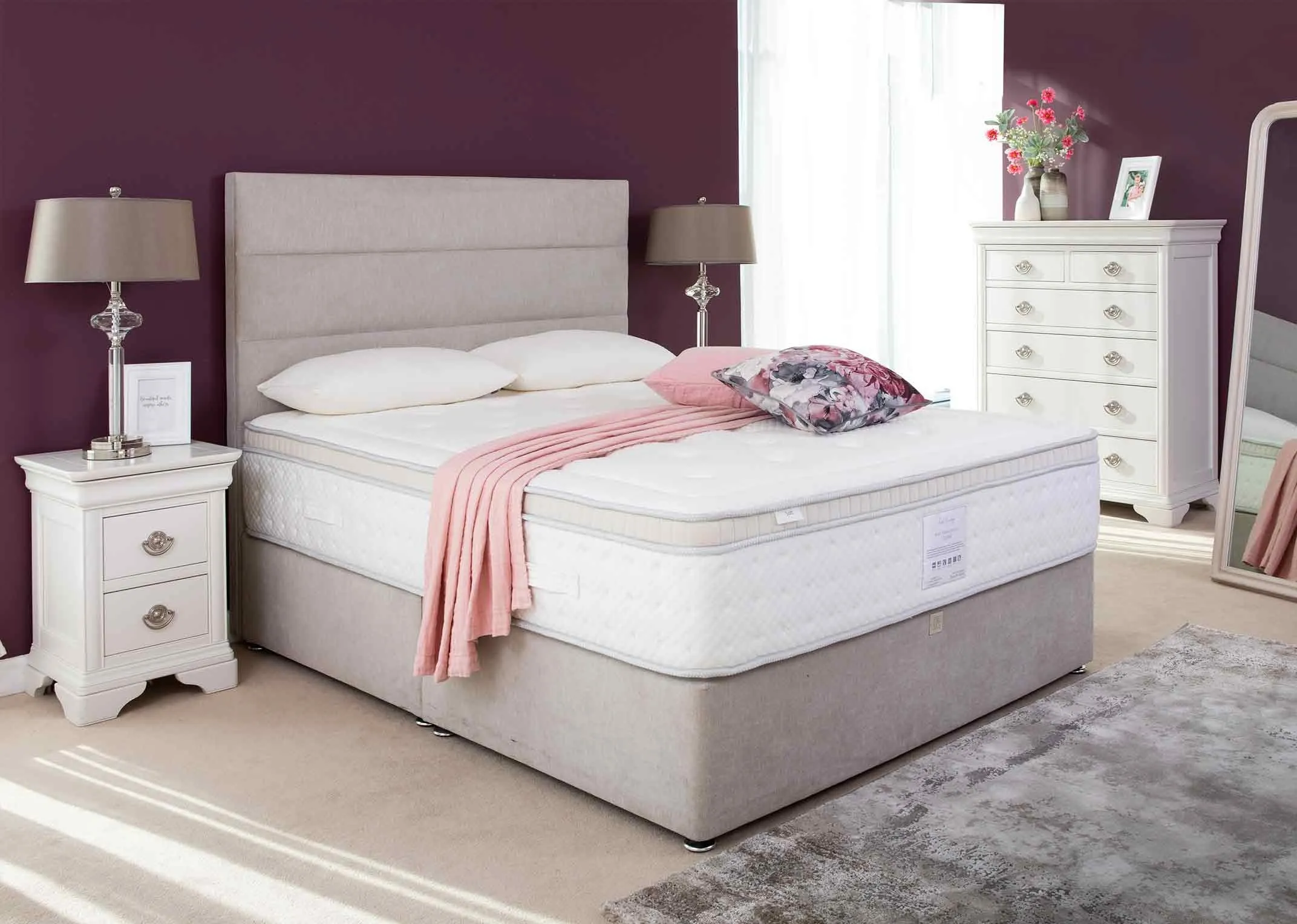 A lifestyle image of the Rian Therapeutic mattress on a bed base with the Chantilly bedroom range.