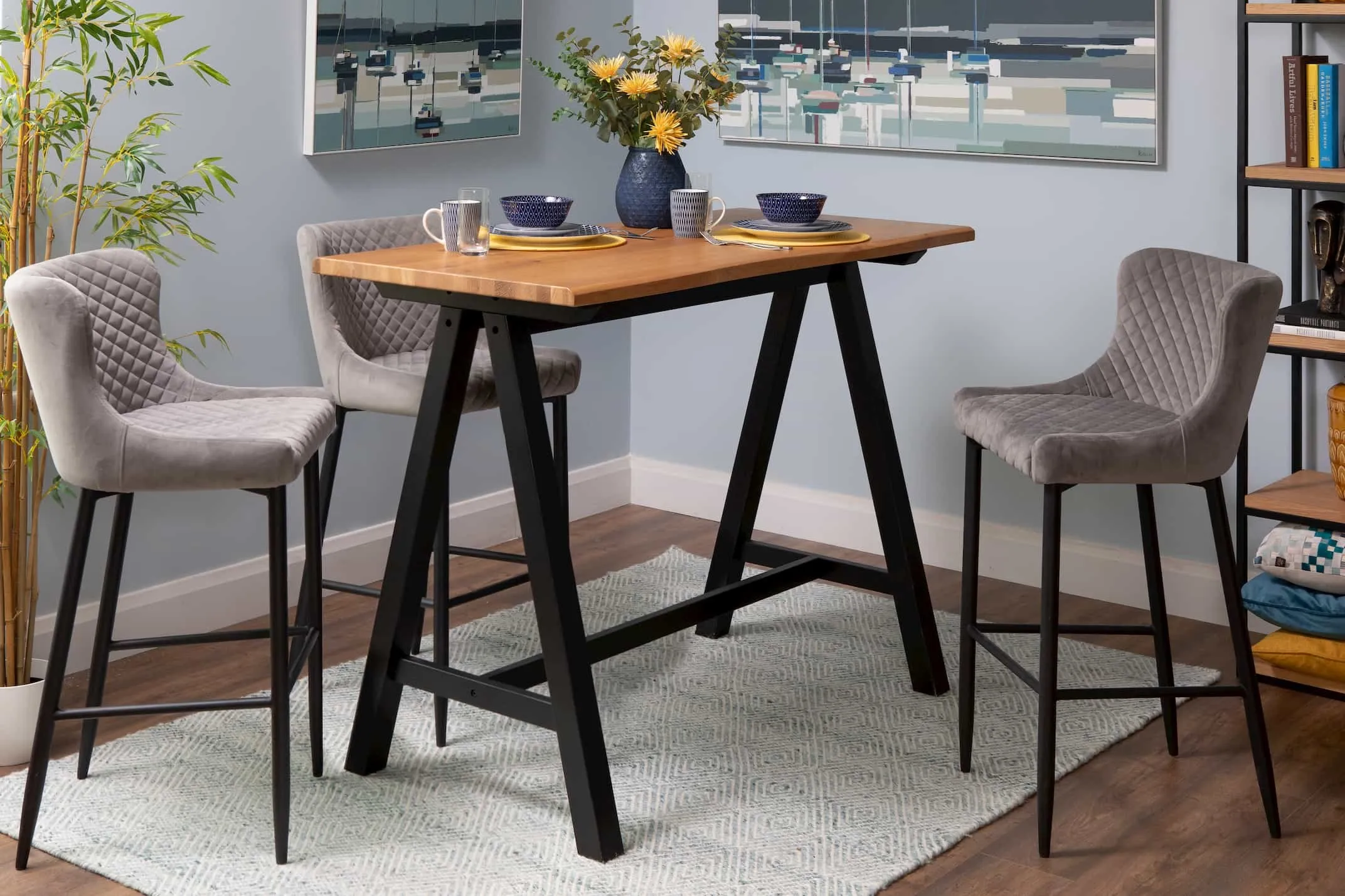 A lifestyle image of the Light Grey Ottowa Counter Bar Stool with the Oliveto Bar Table