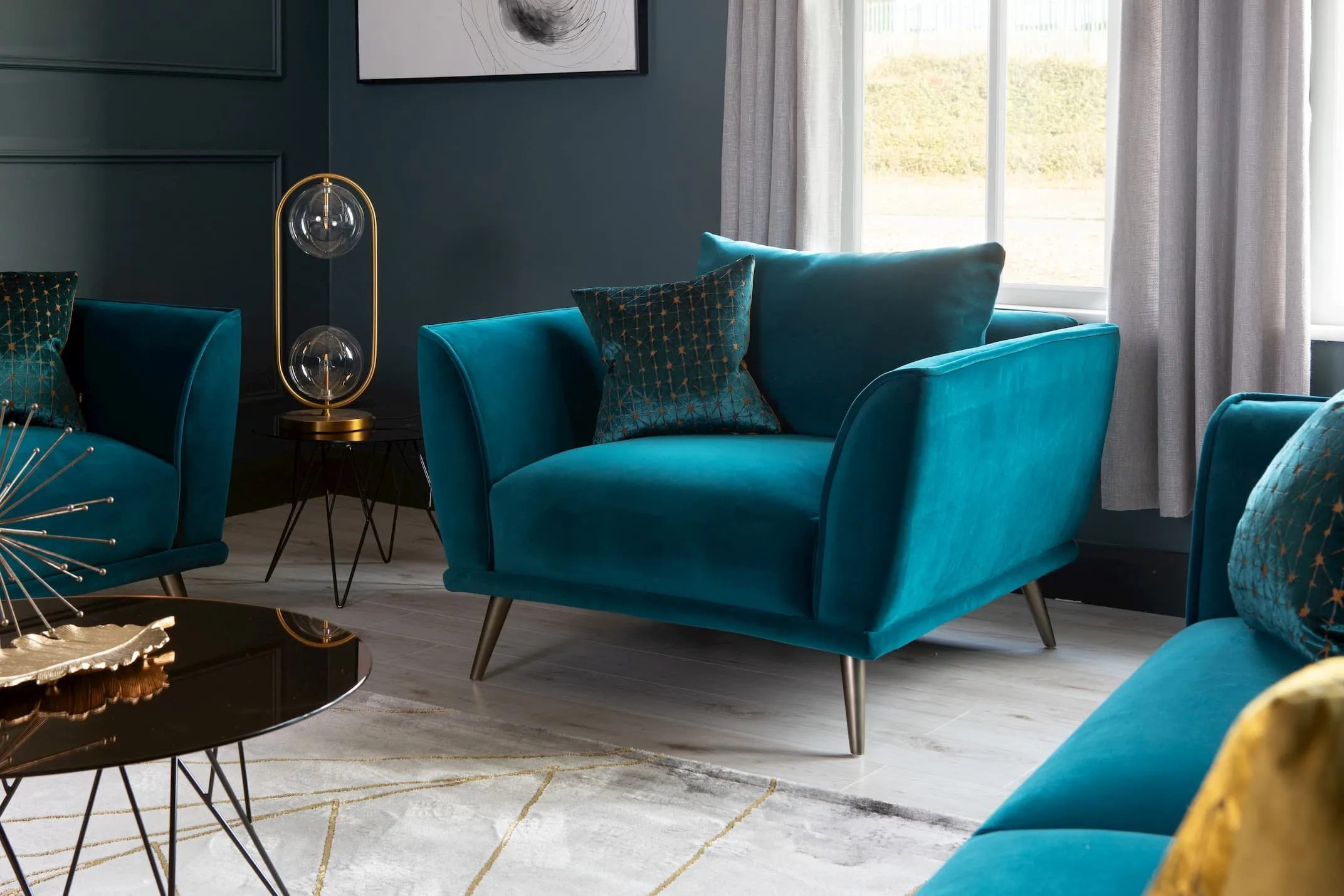 A lifestyle image of the Katie Teal Cuddler with the Prunus Table