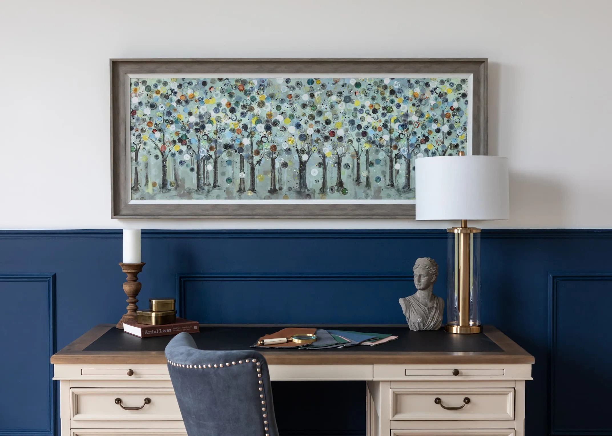 A lifestyle image of Ulyana Hammond's The Timekeeper framed print with the Large Hamsphire desk & Visby gold lamp