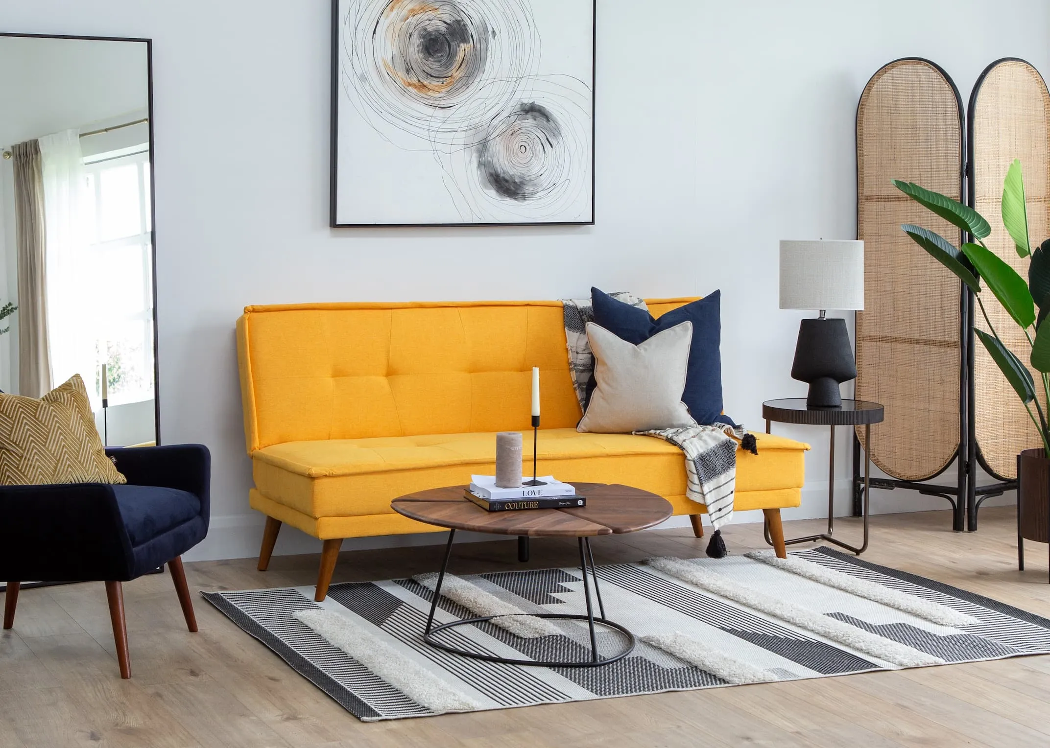 A lifestyle image of the Seattle yellow sofabed as a sofa with Janey chair & shard coffee table with Aztec rug.