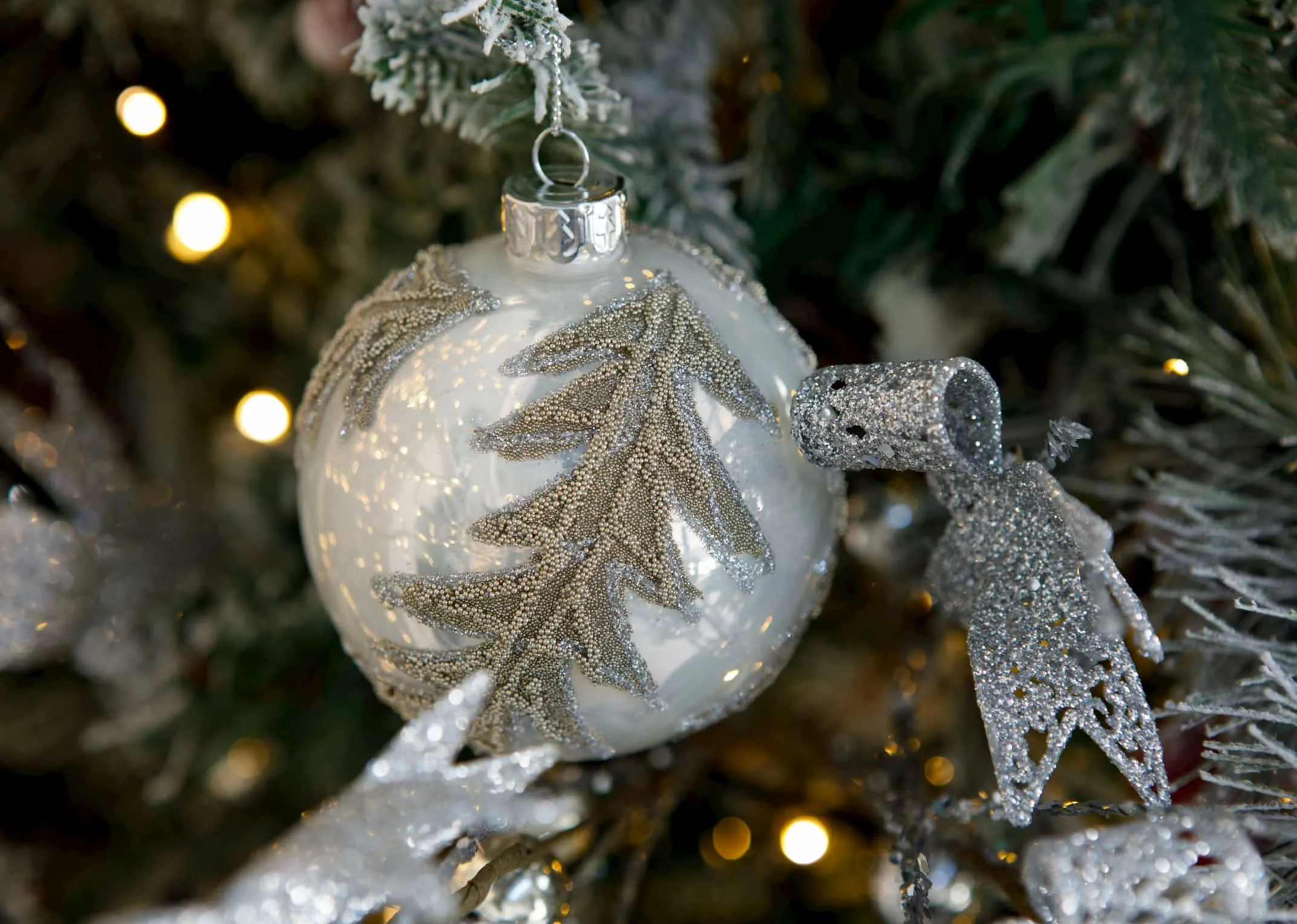 A lifestyle image of the White & Gold Leaf Bauble on a Christmas tree from EZ Living Furniture.