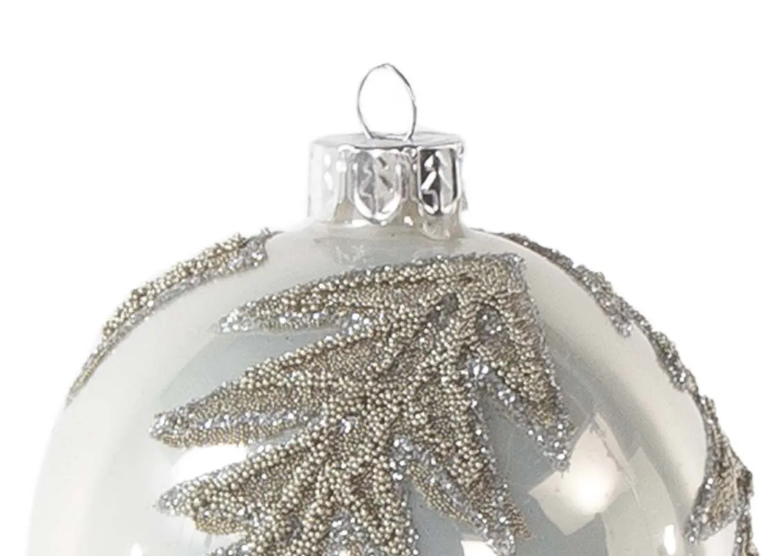 A white glass bauble with gold glitter relief from EZ Living Furniture's Christmas range. Closeup of tree print