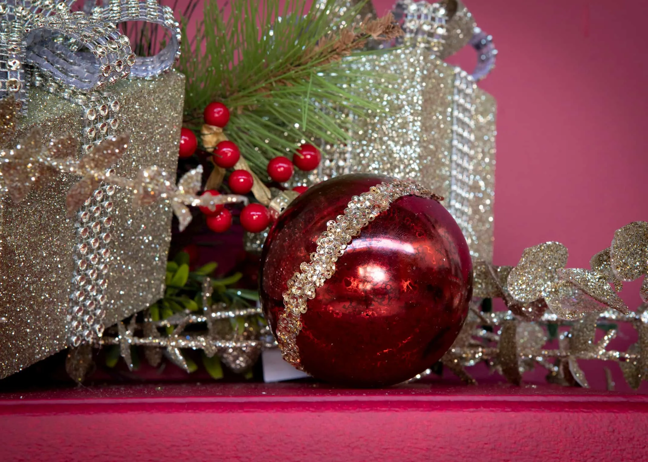A metallic red glass bauble with a thick band of gold/silver diamante from EZ Living Furniture's Christmas range.Closeup view