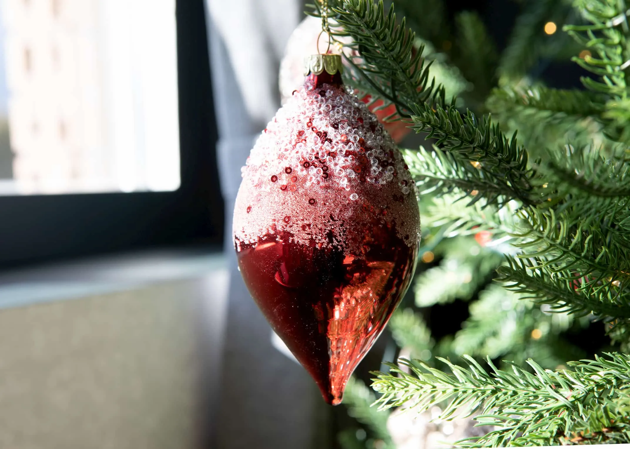 A red teardrop shaped bauble topped in silver diamante from EZ Living Furniture's Christmas Collection. Closeup of diamante