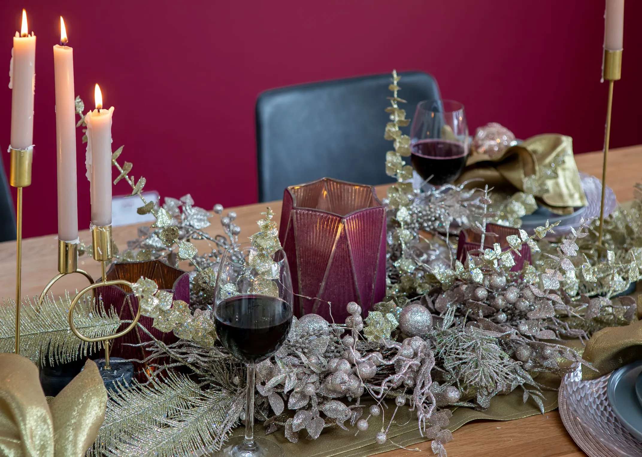 A lifestyle image of the Renvyle table with Red deco candle holder & pink spray