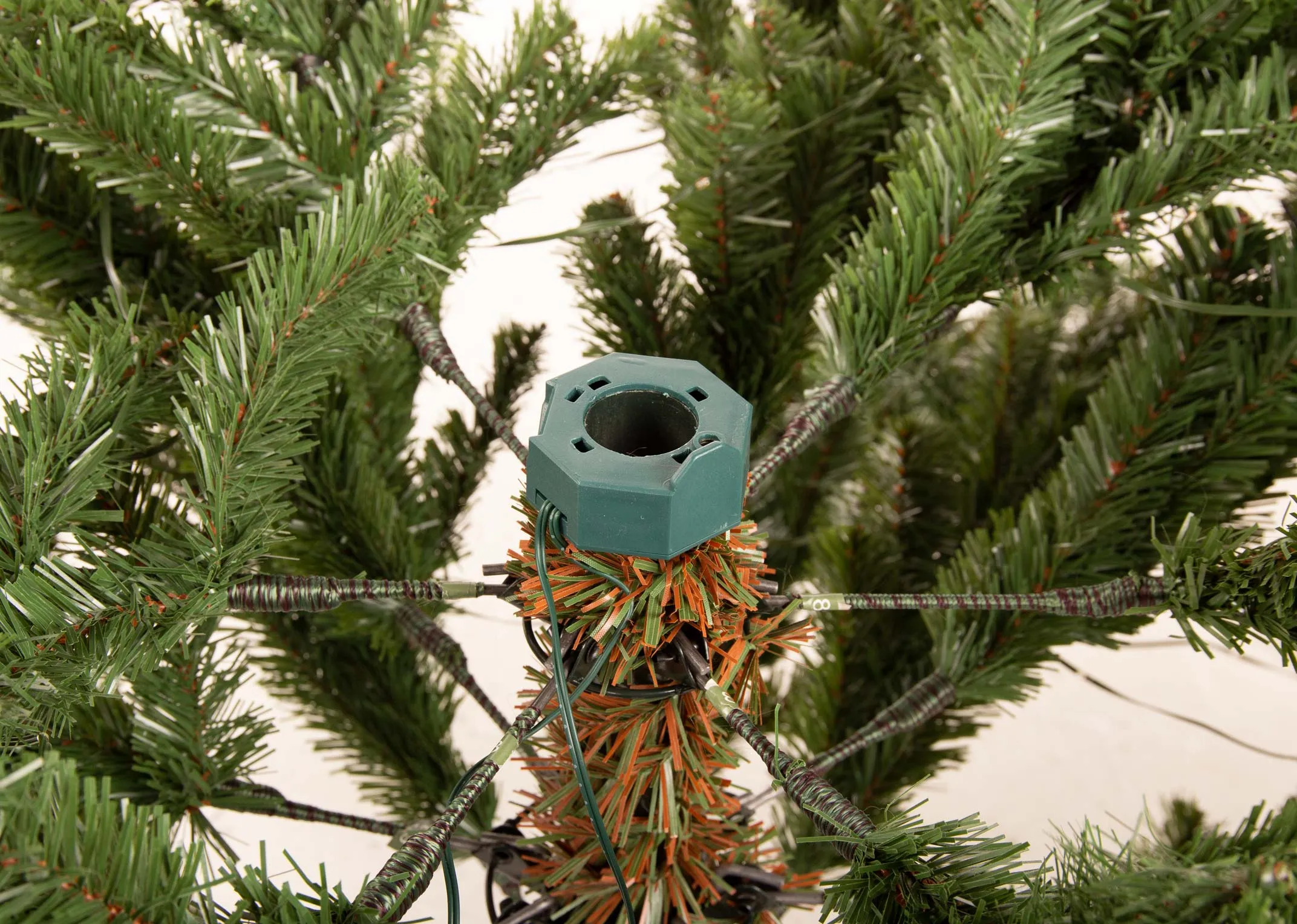 An 8ft green Christmas tree on a stand from EZ Living Furniture's Rockefeller range. Closeup of the tree parts now attached
