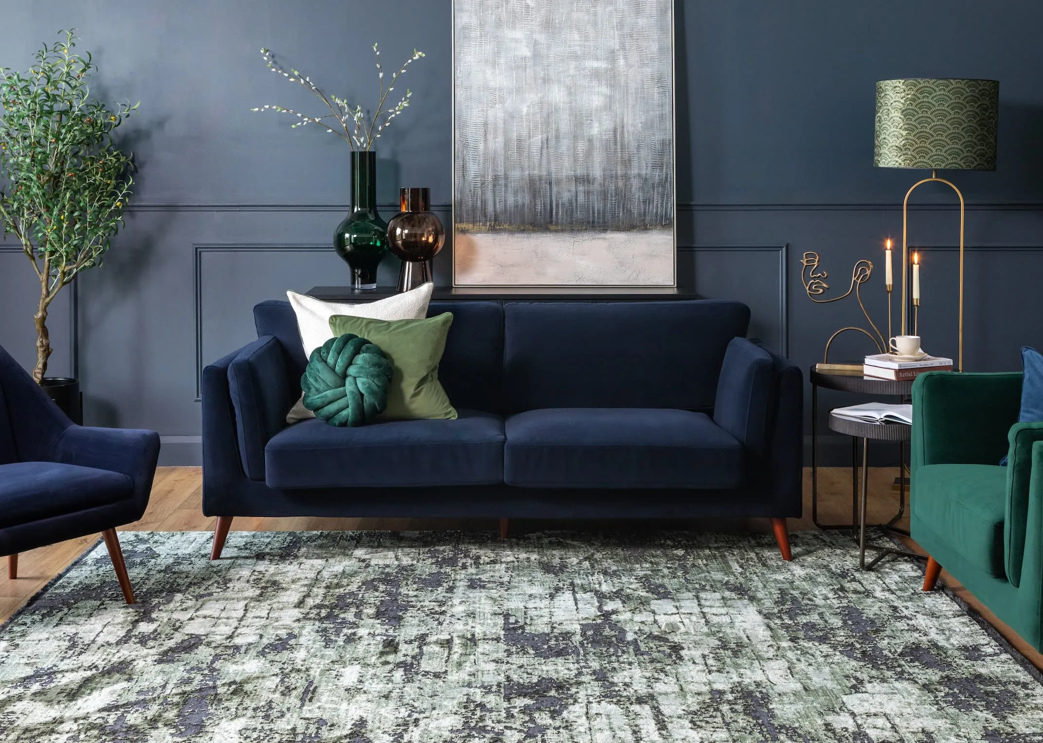 A lifestyle image of the Bellini navy sofa with Rima rug and Stormy canvas