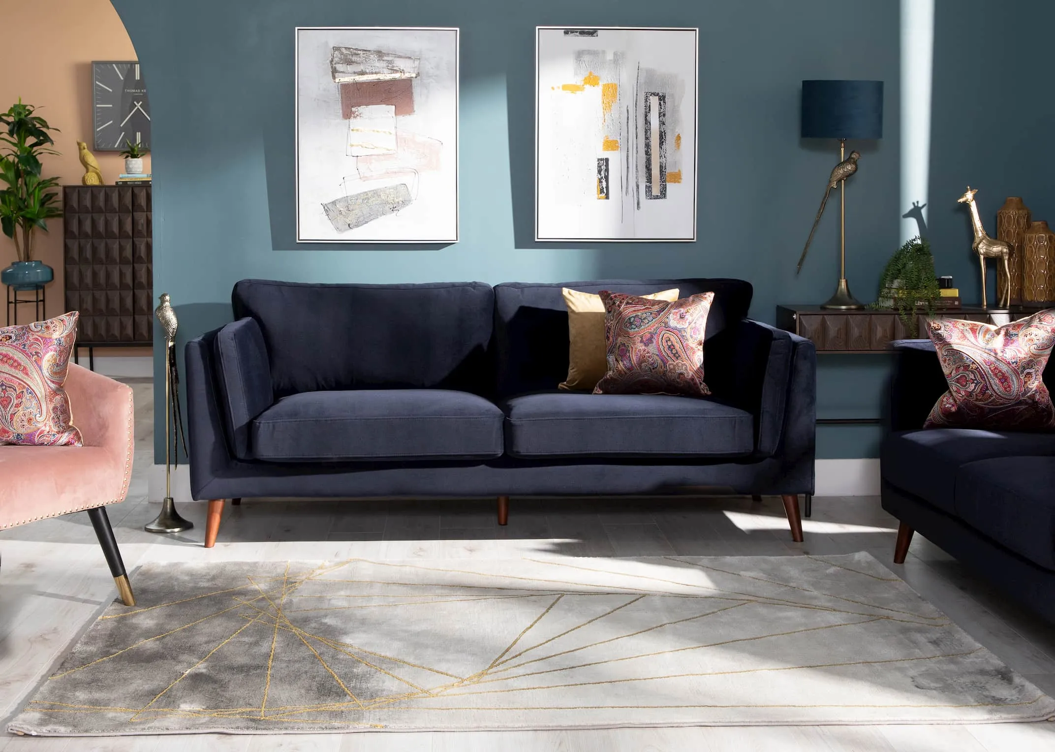 A lifestyle image of the Navy Bellini sofa to show the color of the fabric of footstool in the light