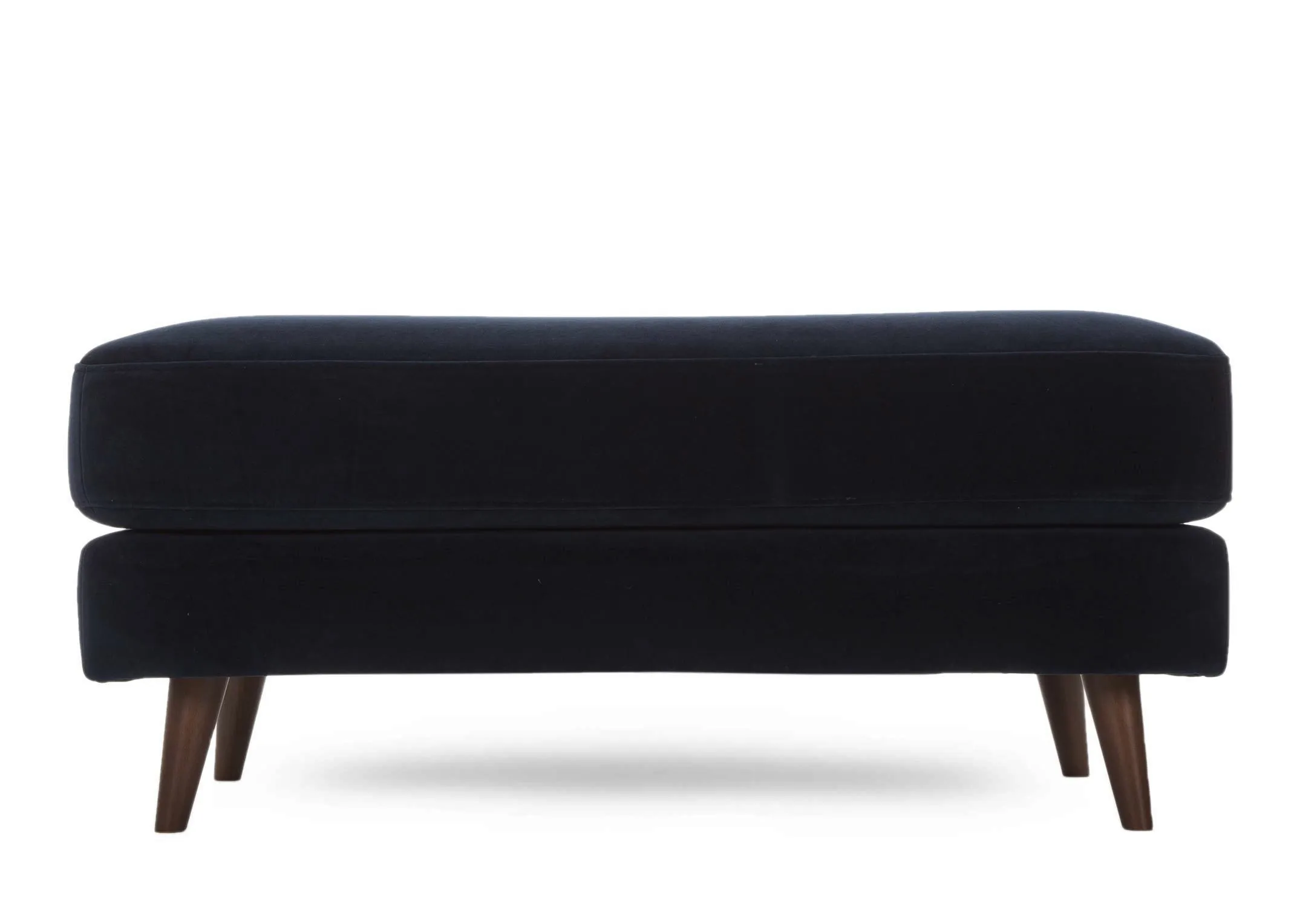A large navy velvet footstool with dark wood feet from EZ Living Furniture's Bellini range. Front view of footstool feet