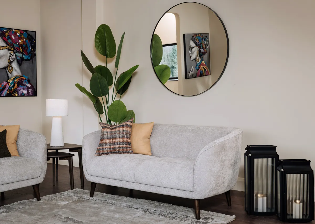 A lifetsyle image of the Amber 2 seater sofa with Elling black mirror and Contessa print.