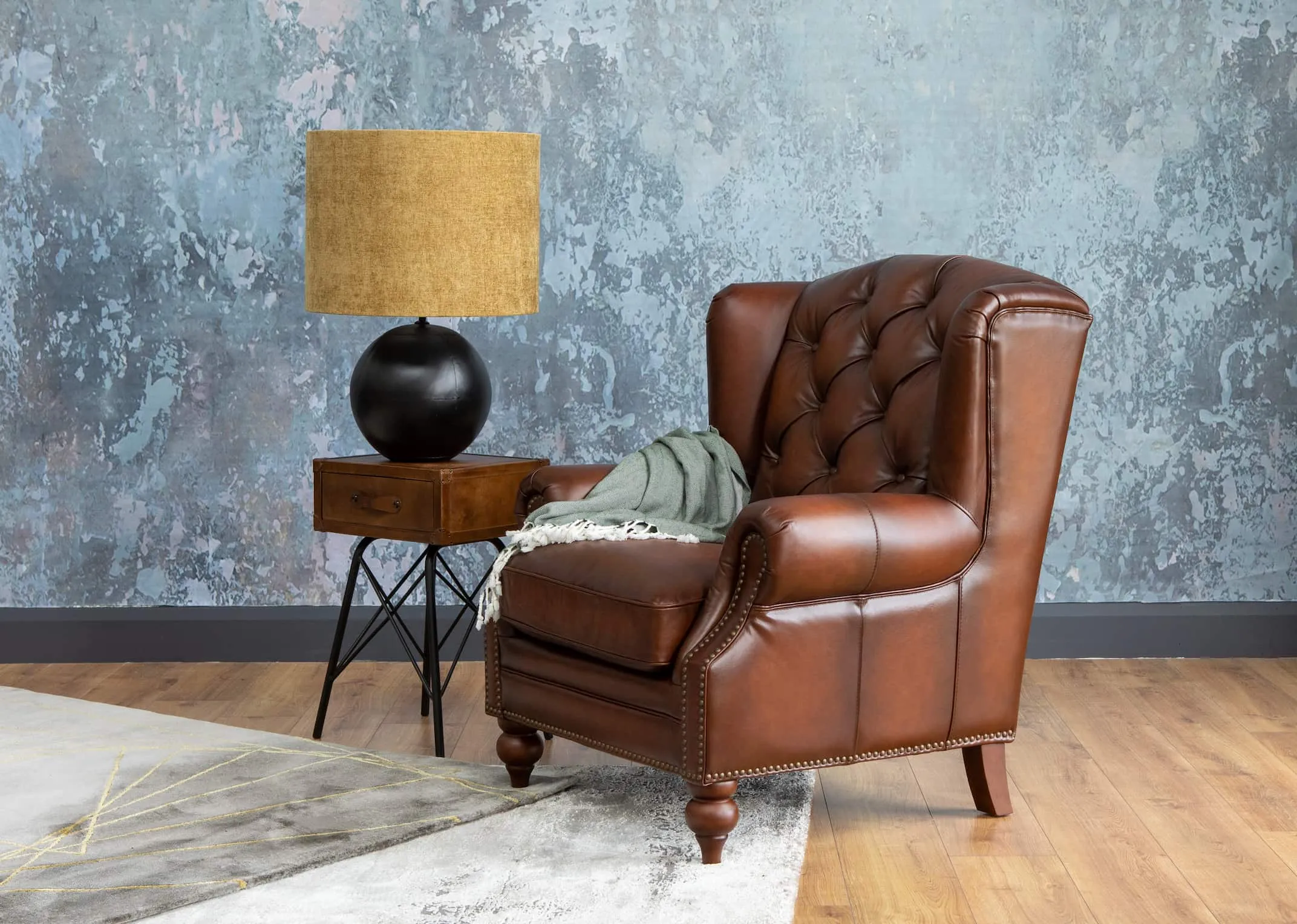 A lifestyle image of the Adare Wing Chair with nelson table & ebula lamp switched off.