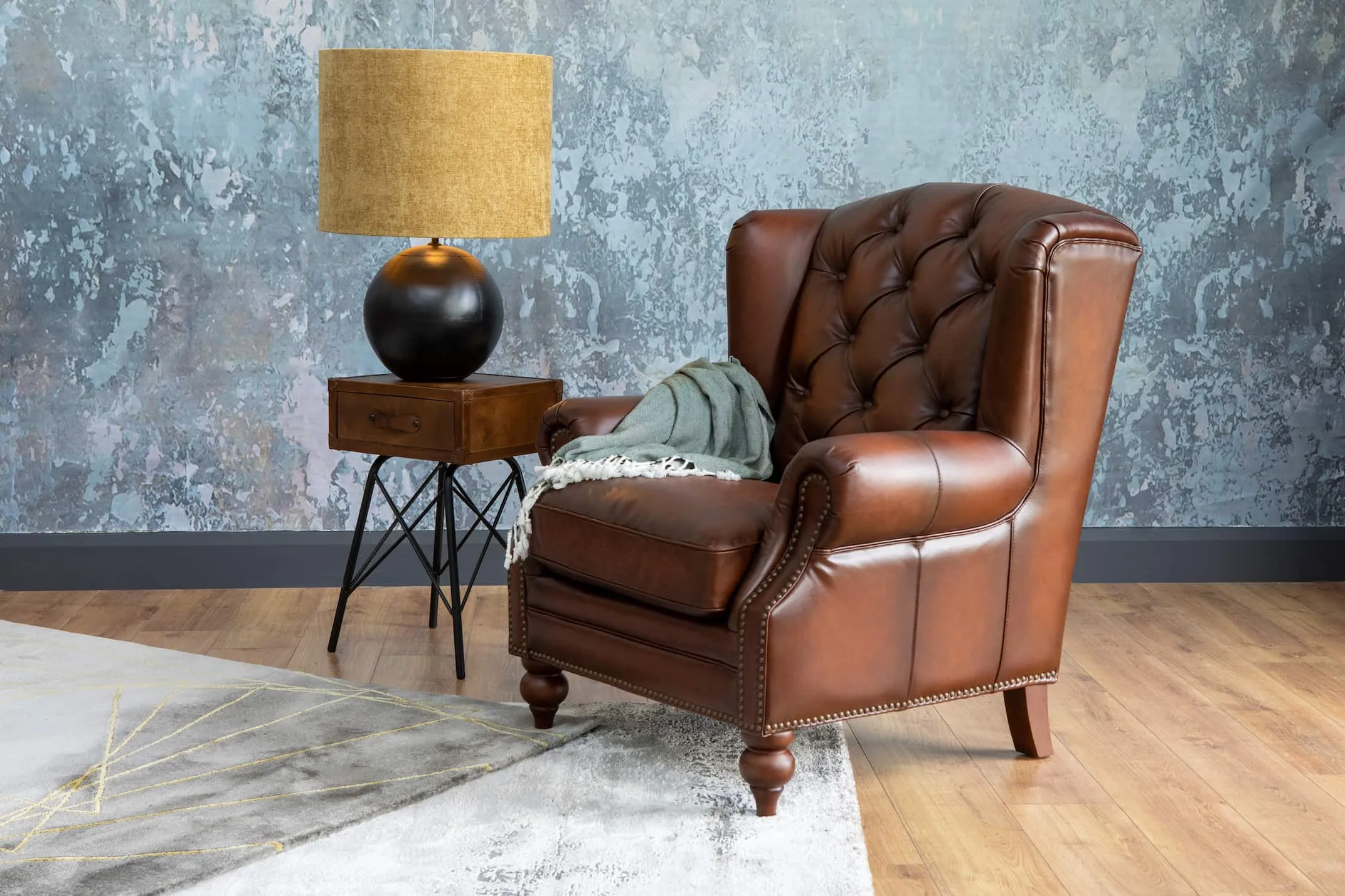 A lifestyle image of the Adare Wing Chair with nelson table & ebula lamp switched on.