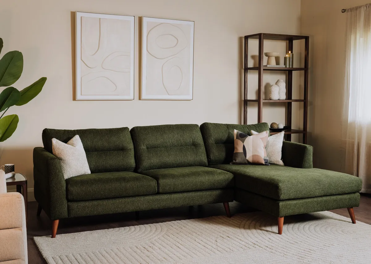 A lifestyle image of the Presley green corner chaise with Cameo bookcase