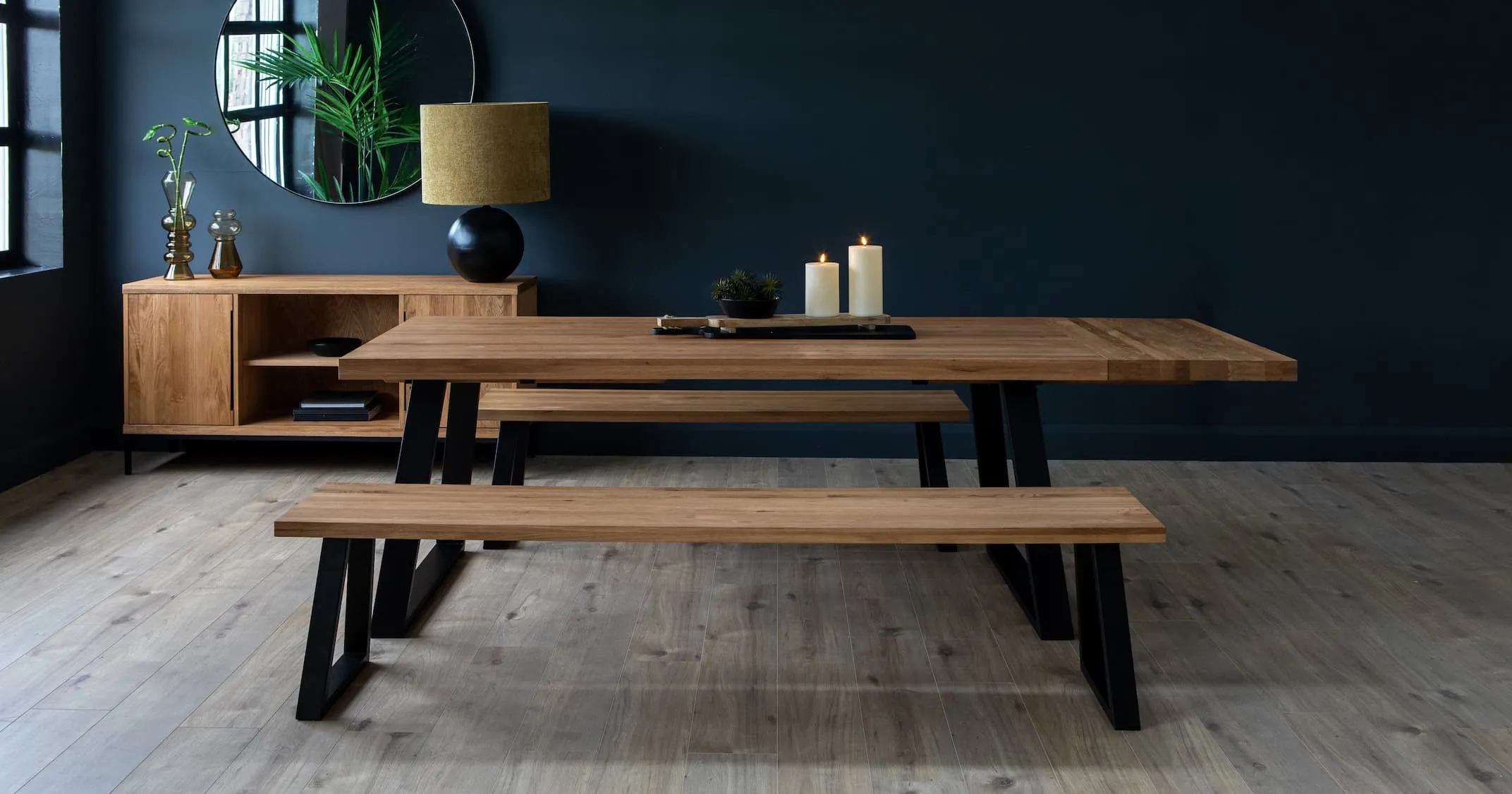 A lifestyle image of the Renvyle Dining table & bench in large & sideboard with bolcho lamp.