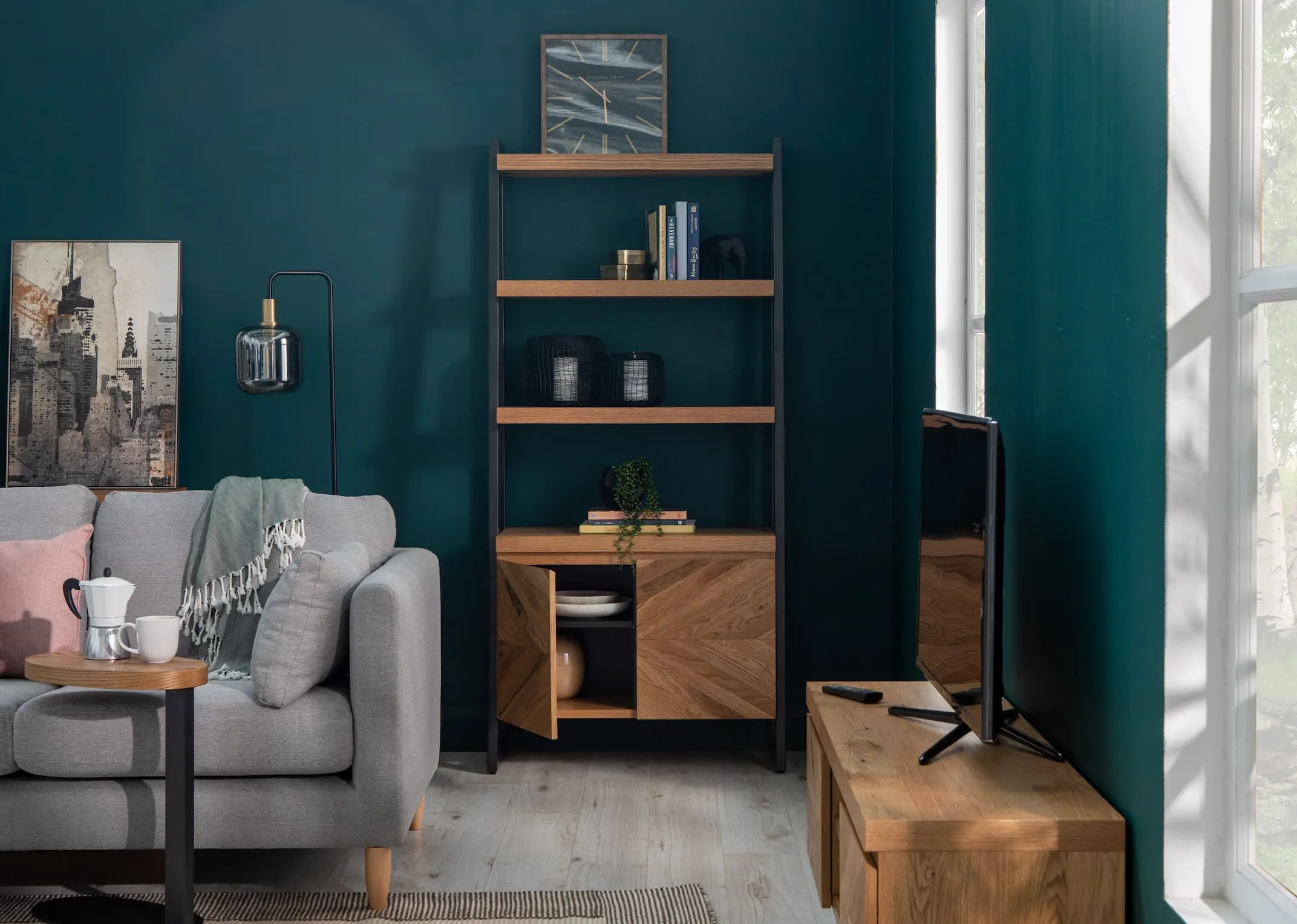 A lifestyle image of the Alamo 2 Seater grey sofa with Ellipse display unit with garrick clock