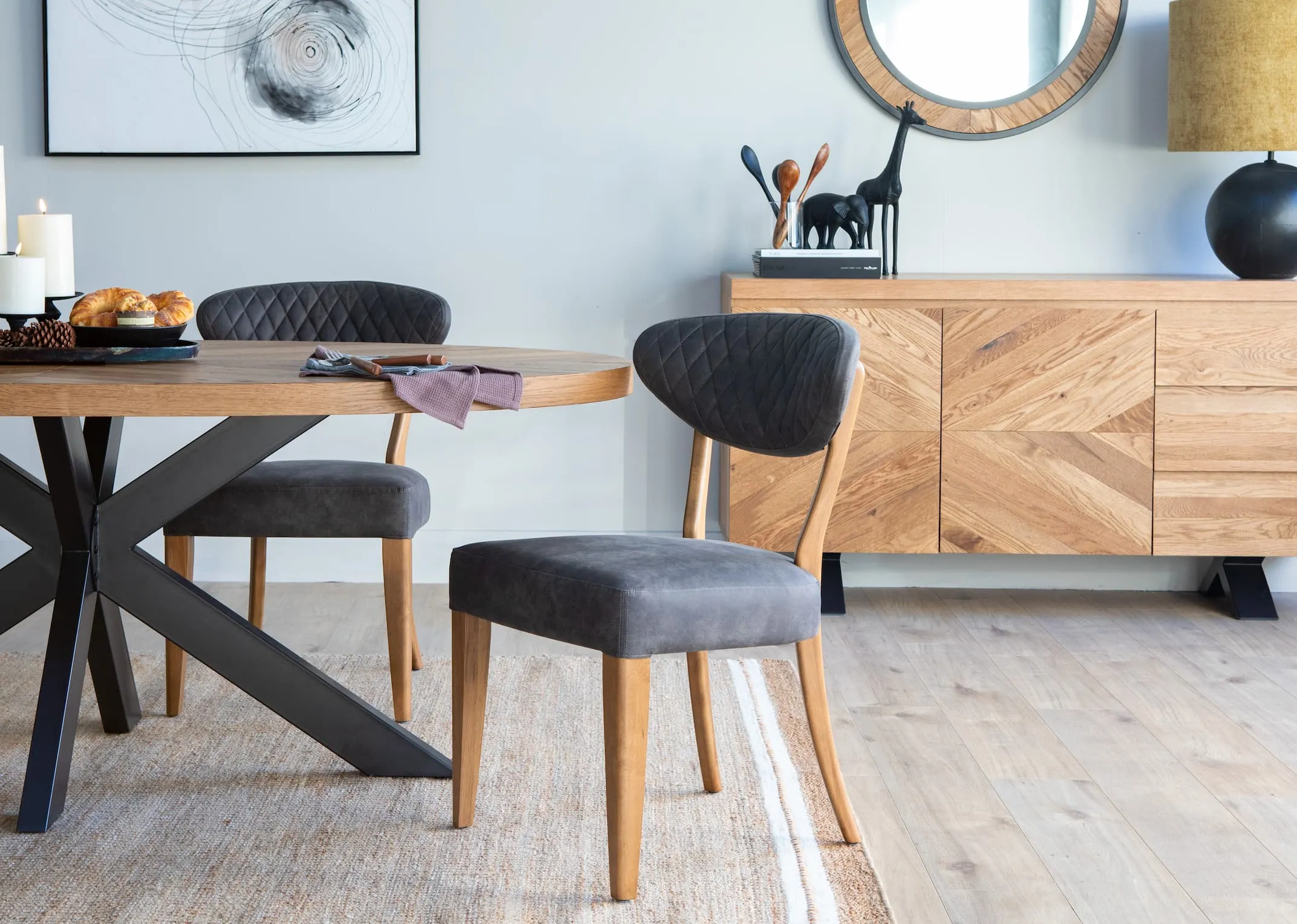 A lifestyle image of the grey fabric Margot dining chair with the ellipse dining range from EZ Living Furniture.