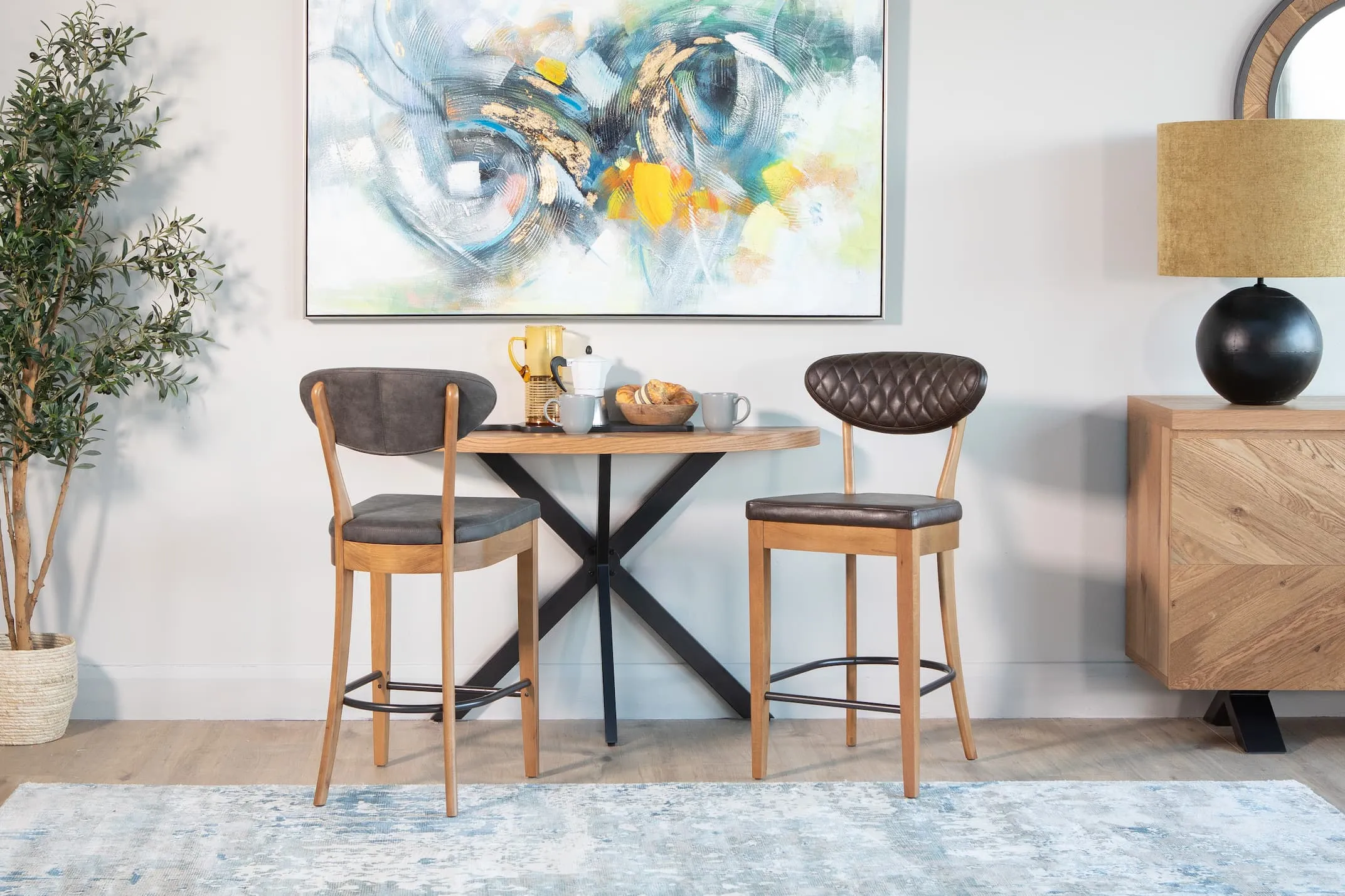 A lifestyle image of the Ellipse rustic console as a bar table with Margot Fabric & leather bar stools.