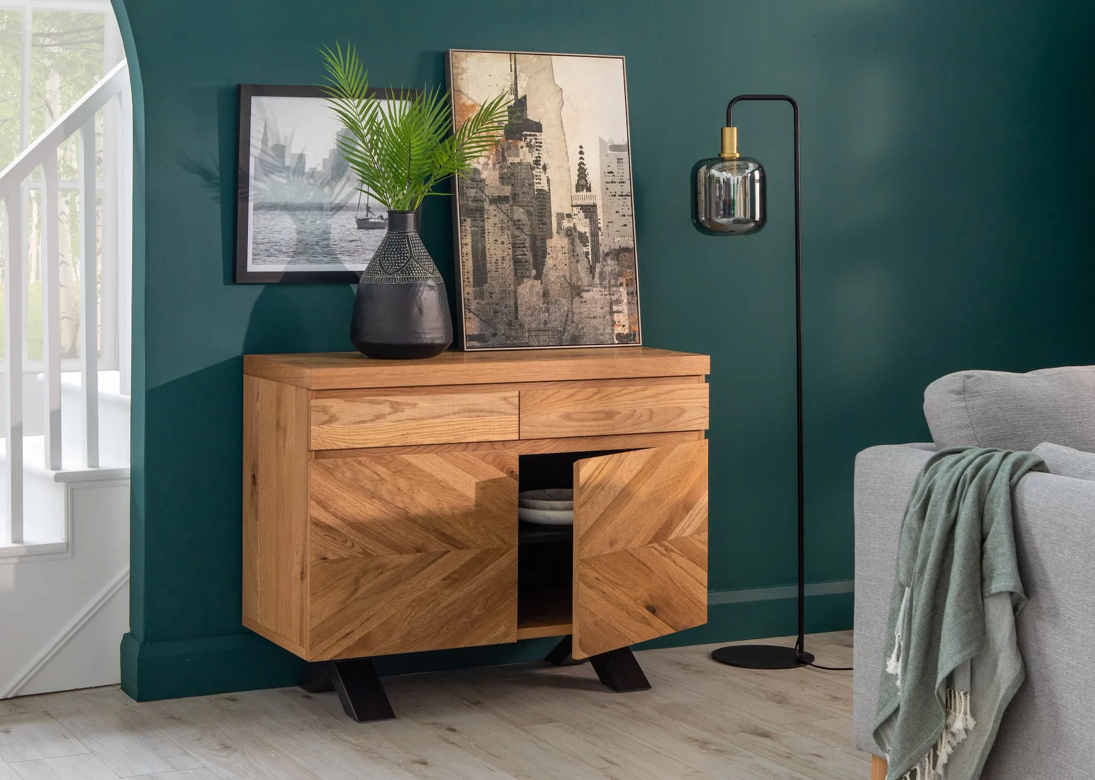 A lifestyle image of the Ellipse Sideboard with Lekar lamp & New York Highlife