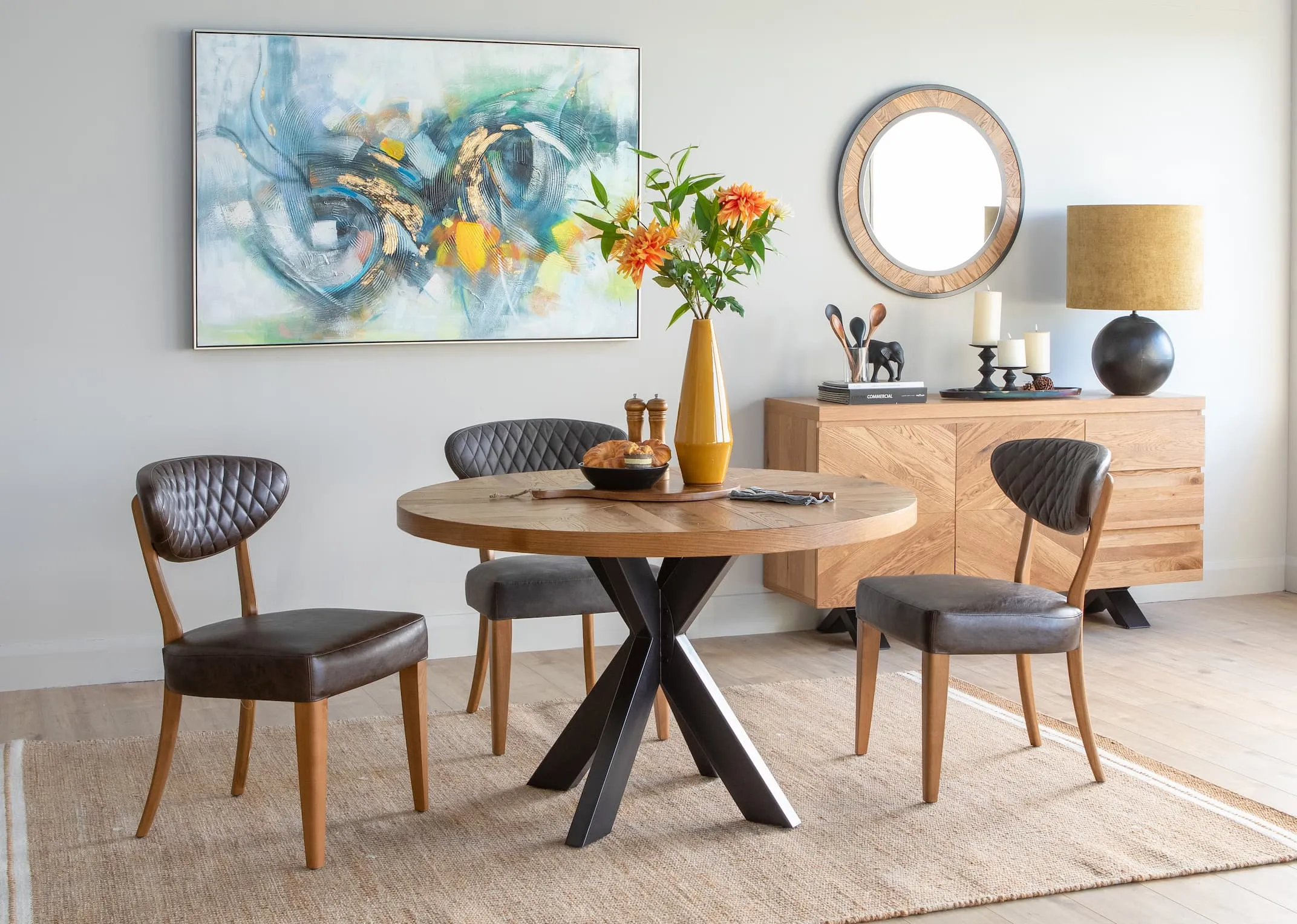 A lifestyle image of the grey fabric Margot dining chairs with the ellipse dining range& novato oyster rug.