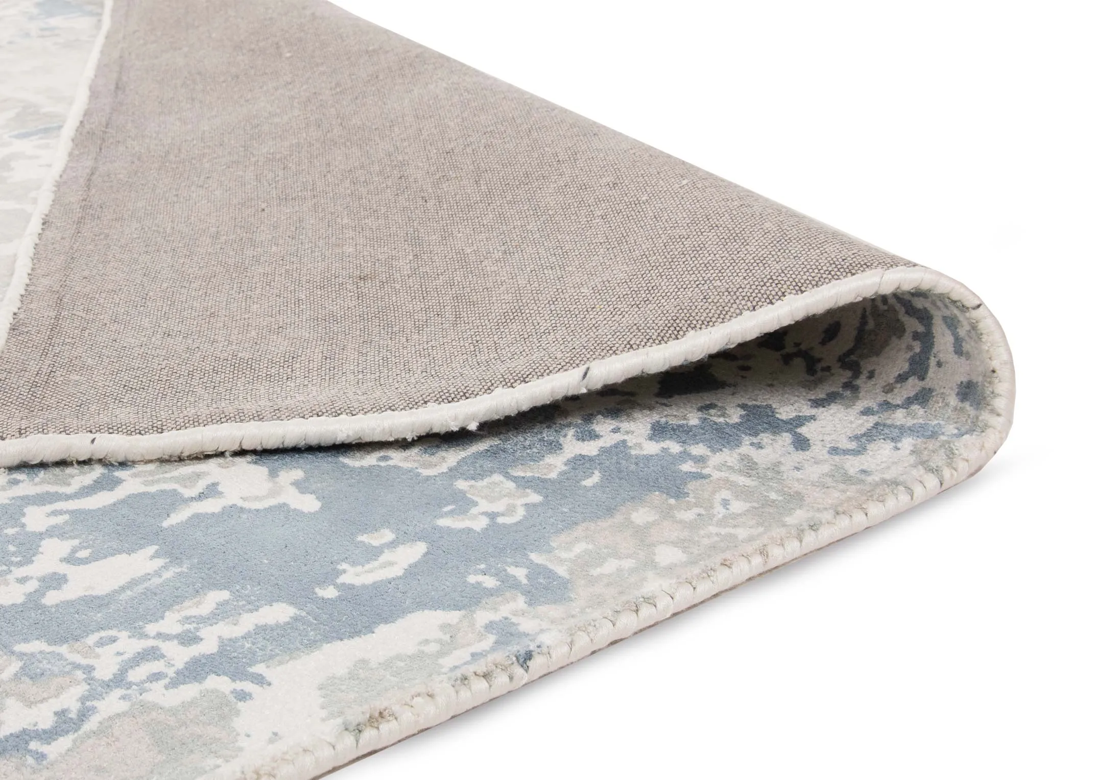 A large blue & silver distressed rug from EZ Living's Moderno range. Closeup of the folded rug