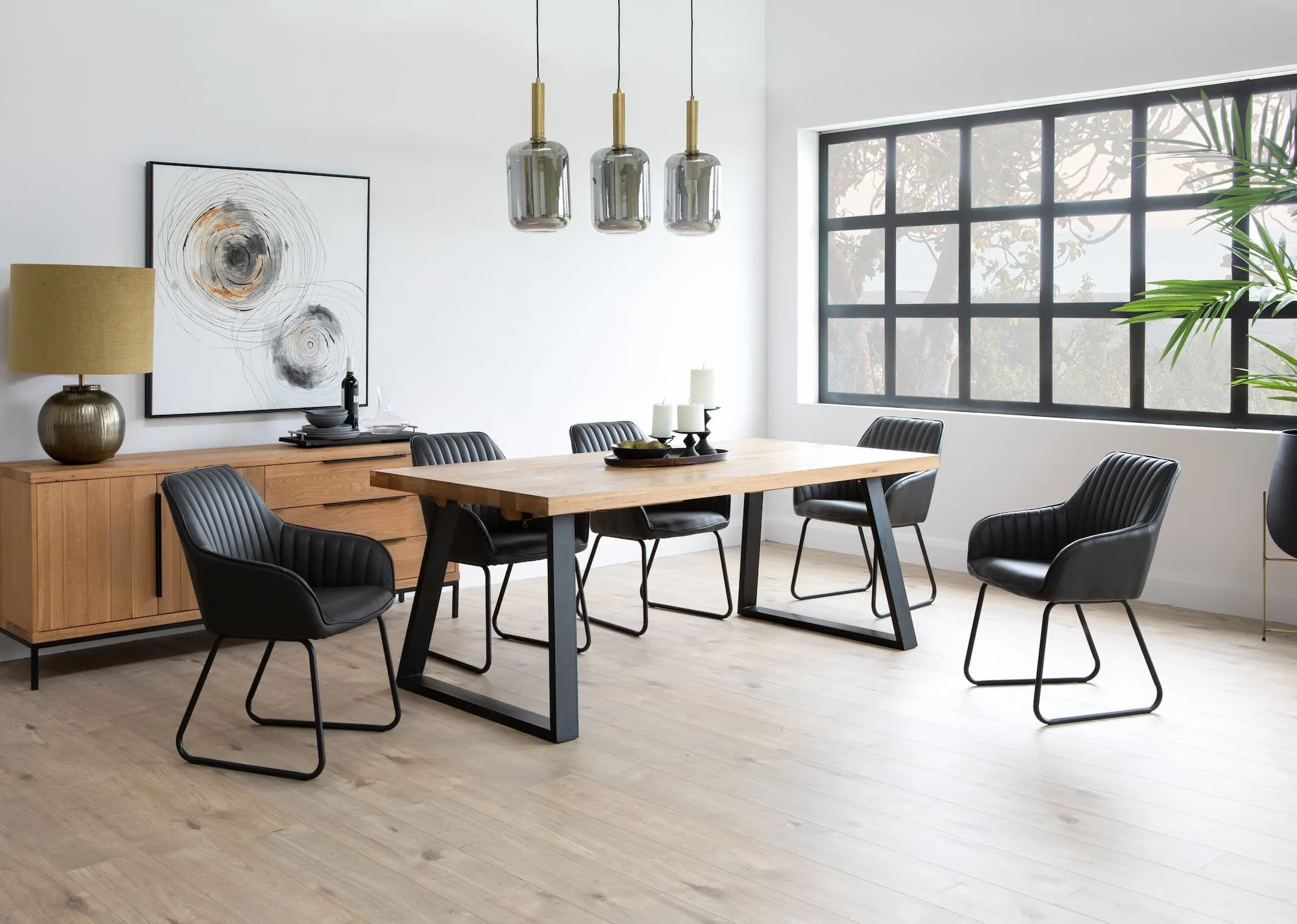 A lifestyle image of the Mila extendable dining table with lekar pendant lamps & sideboard & bradley grey dining chairs