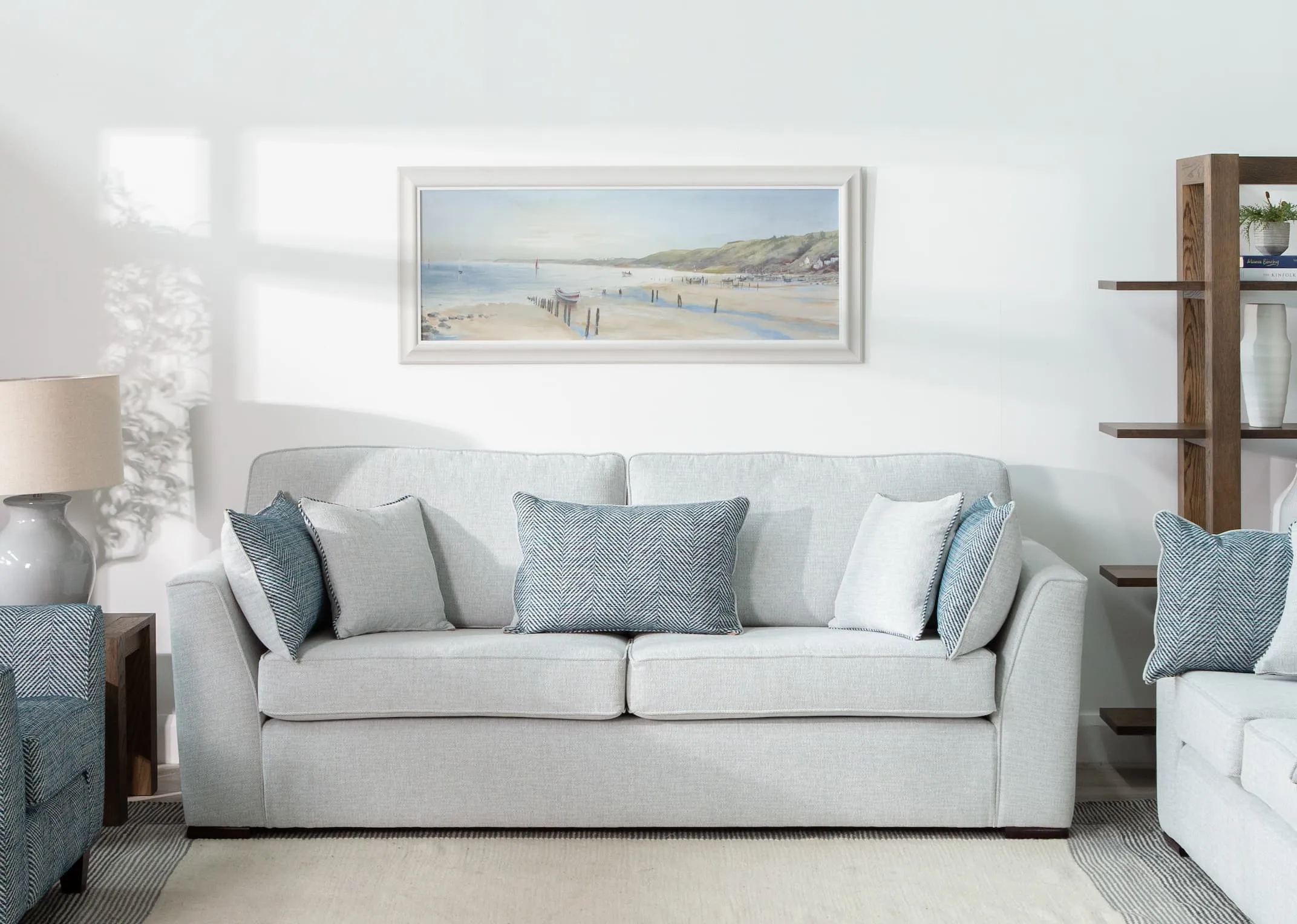 A lifestyle image of the Calm Waters canvas over a light grey sofa