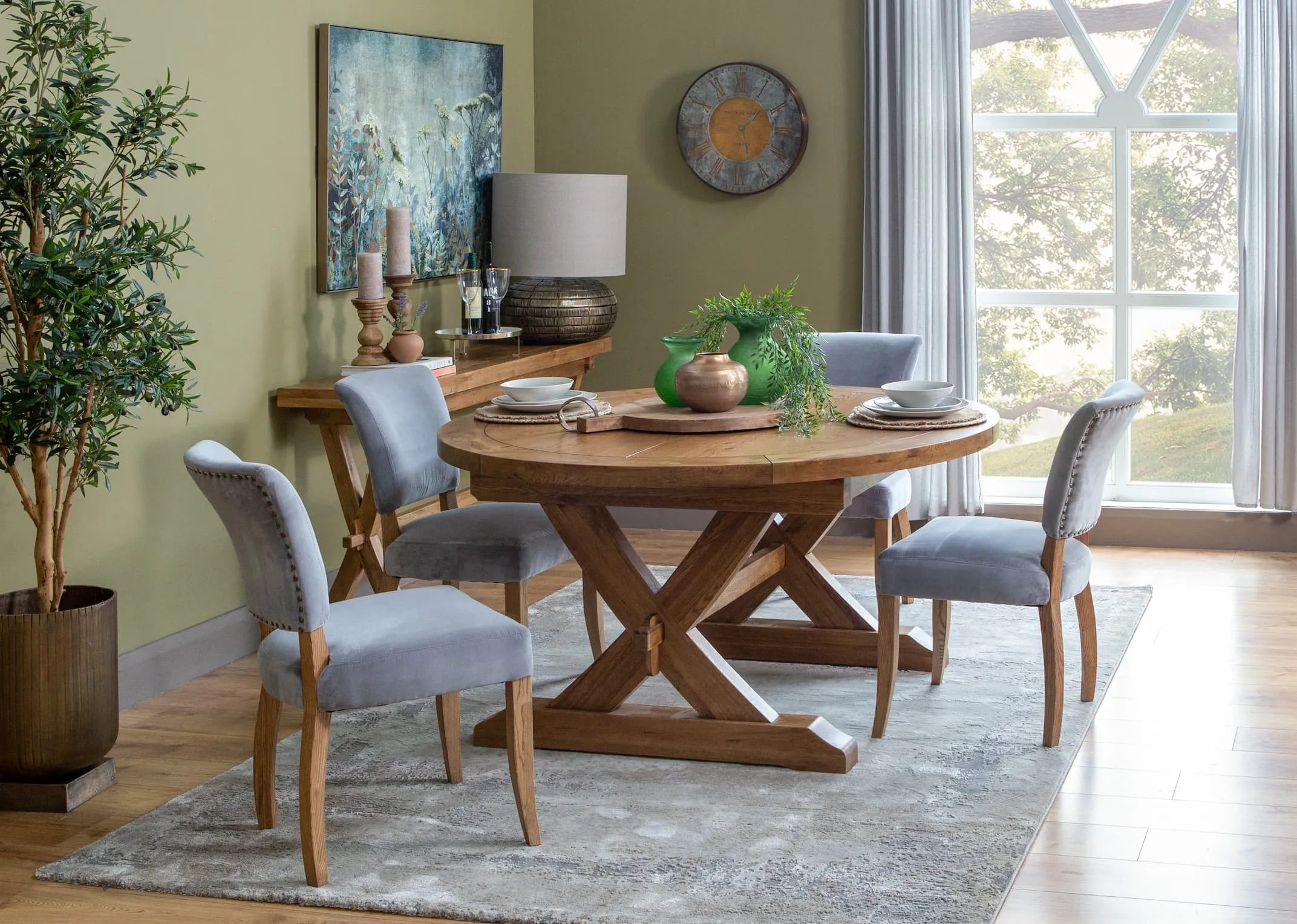 A lifestyle image of the Athens round table with athy grey chairs and Florentine clock.