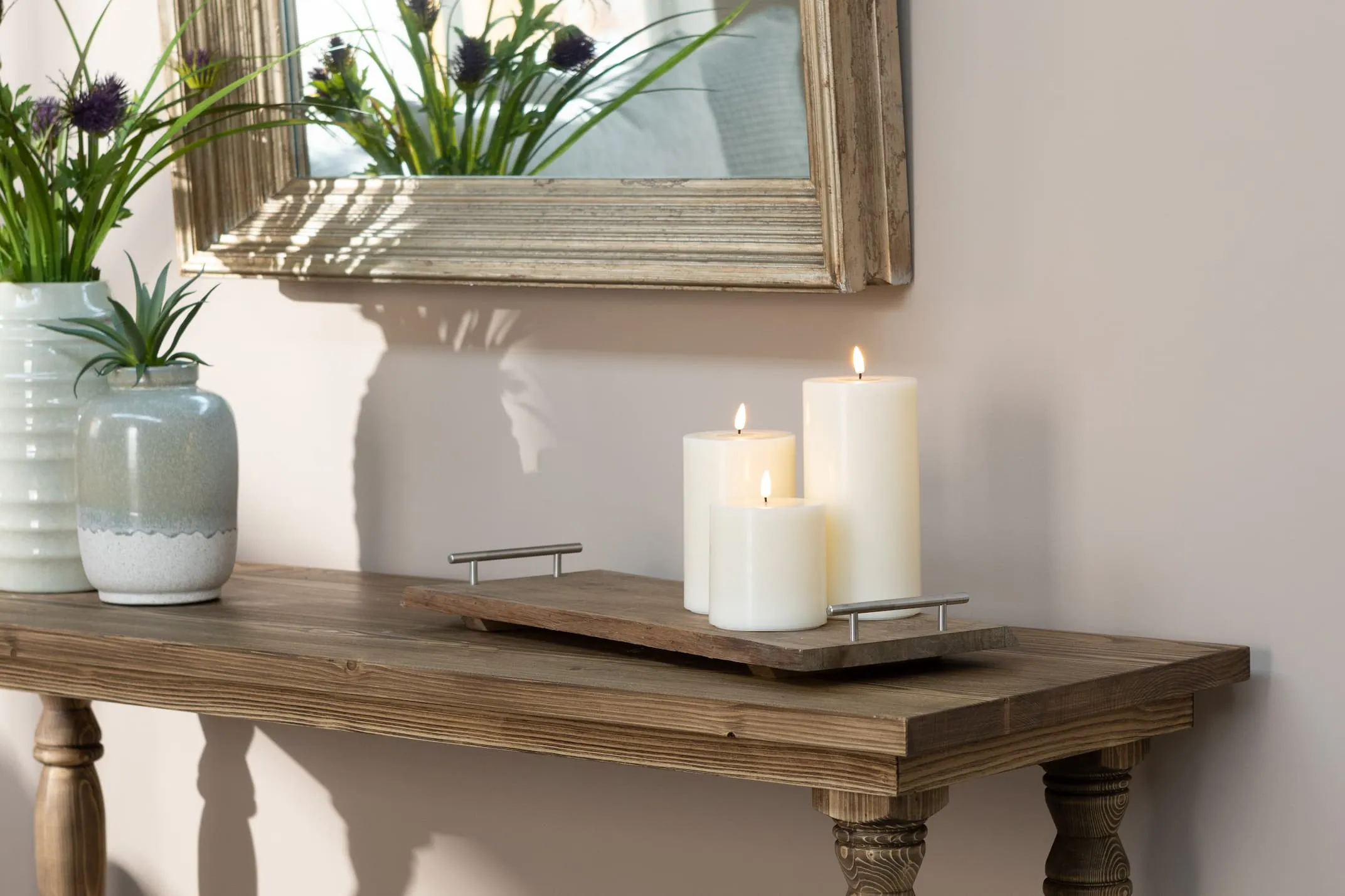 A lifestyle image with the 3 sizes of Cream LED Candles on the Long Island Console table.
