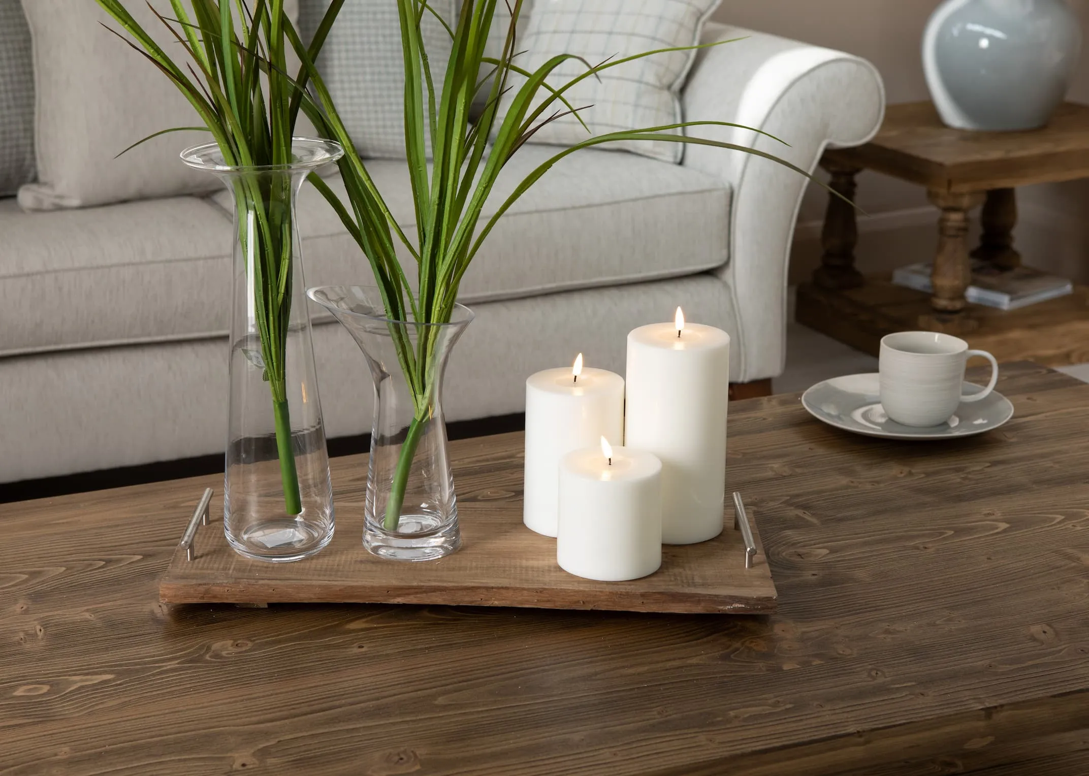 A lifestyle image with the 3 sizes of White LED Candles on the Long Island Coffey Table