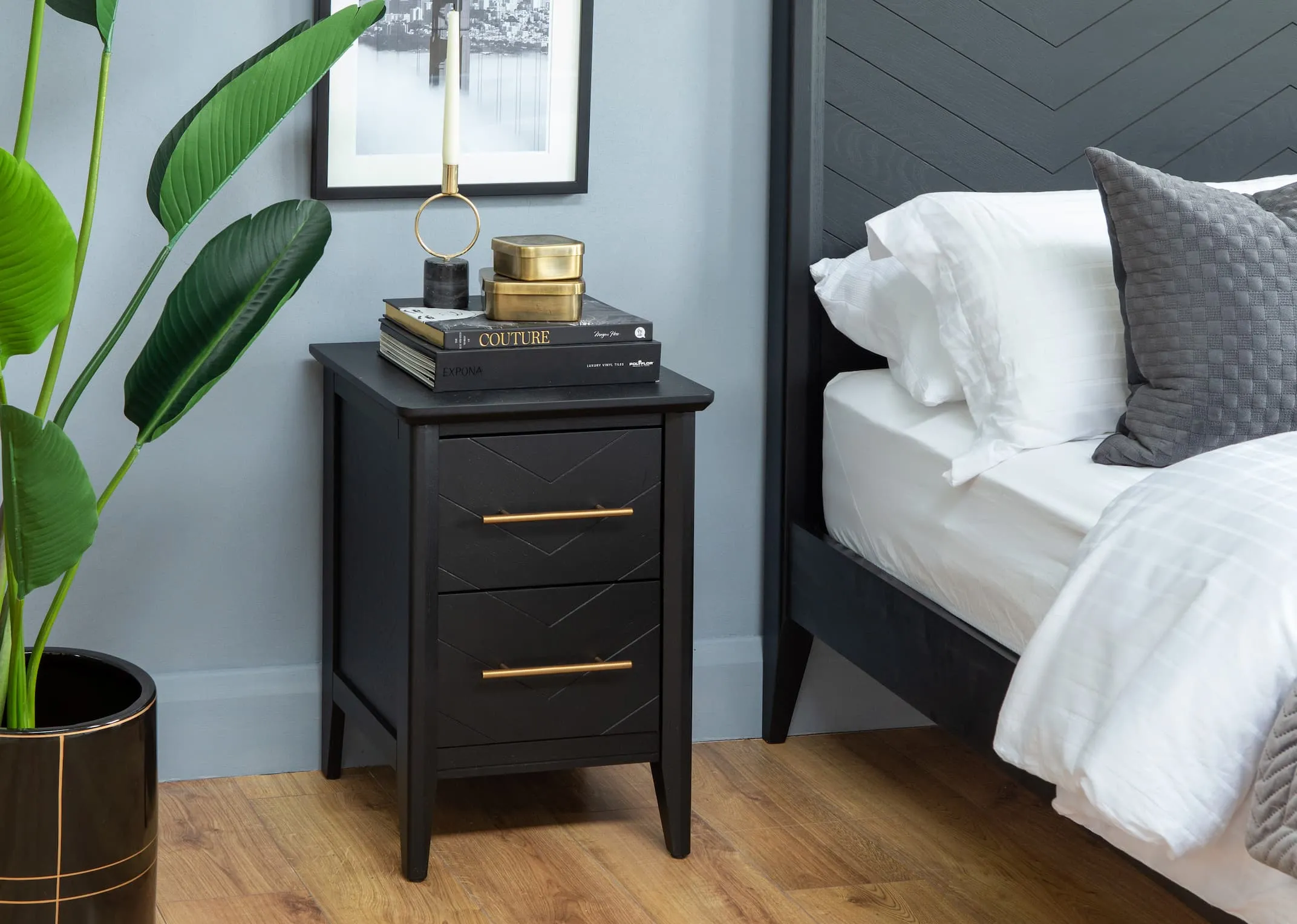 A lifestyle image of the Chevron bedframe with matching black locker with gold accessories