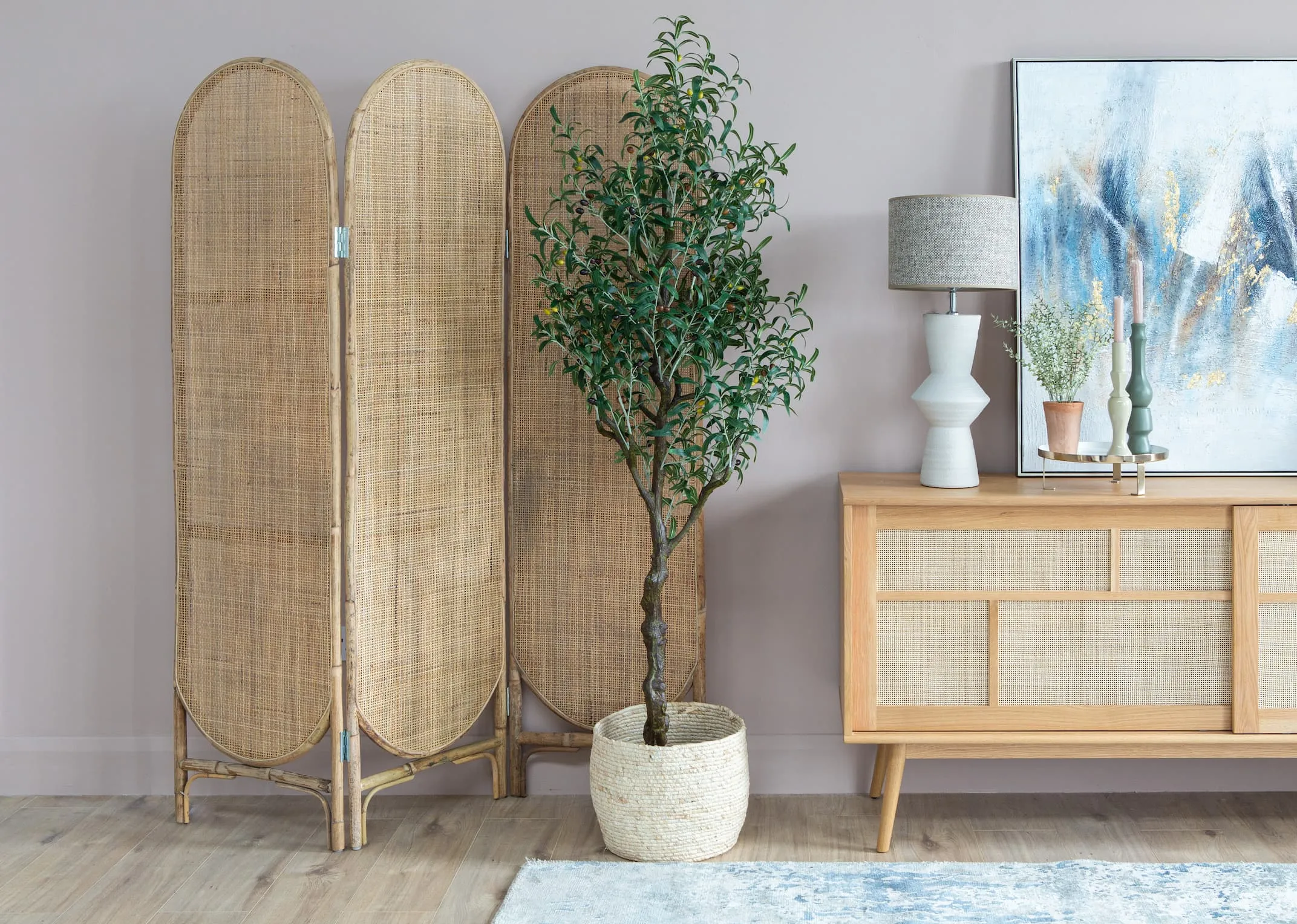 A lifestyle image of the Olive tree in a basket with Herwin room divider & Baralli sideboard and Ayla lamp.