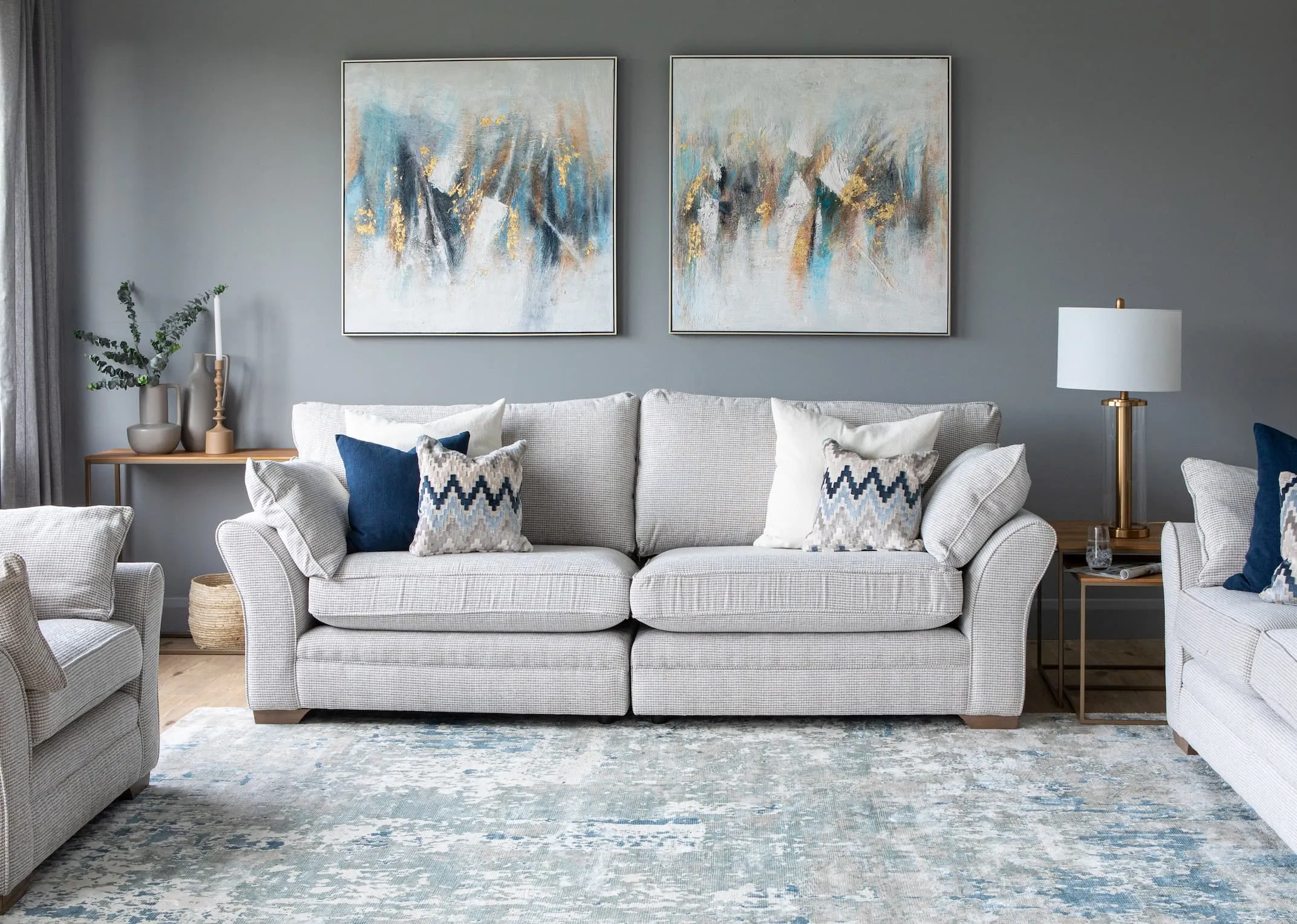 A lifestyle image of the Strata sofa range with abstract & abstract take 2 prints with aston tables & visby lamp.