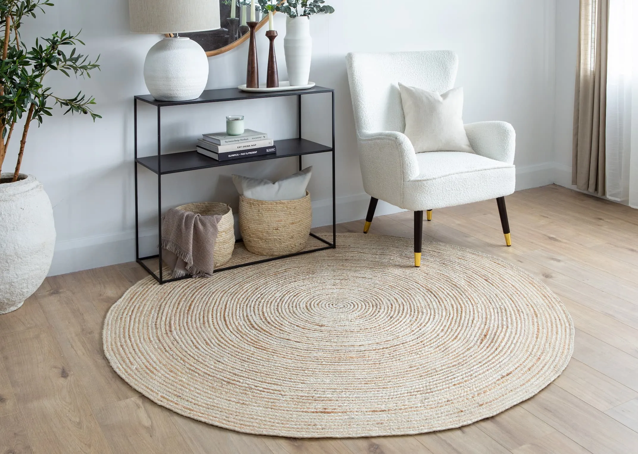 A lifestyle image of the Natural rug with pebble console & shiraz chair