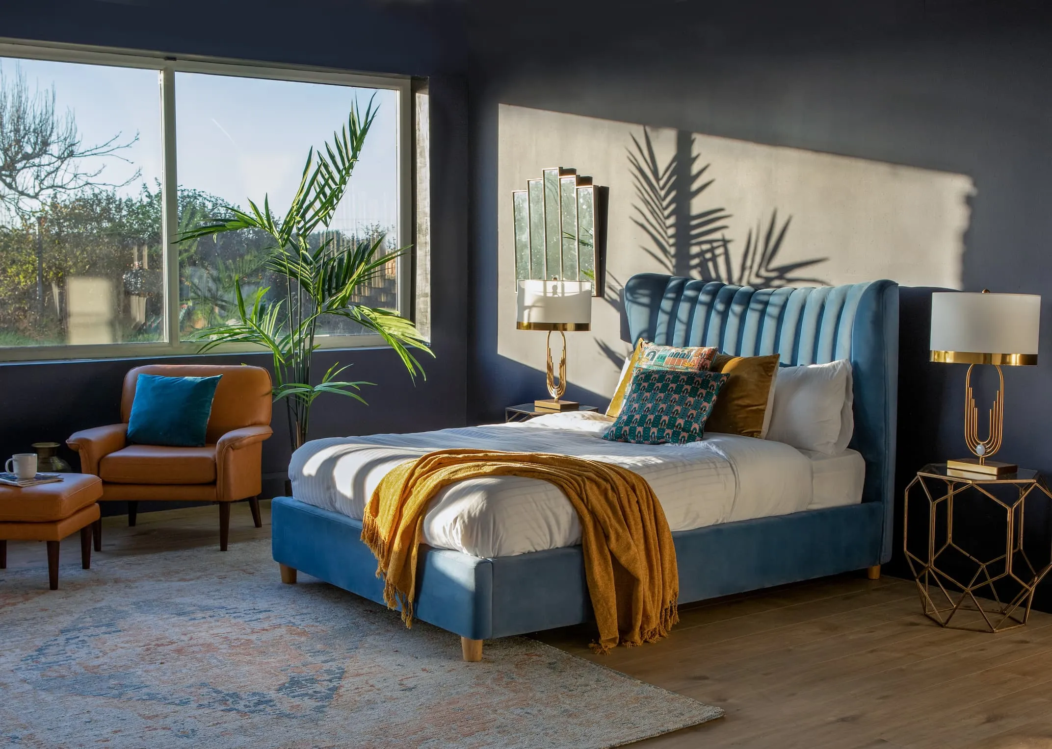 A lifestyle image of the Rosey Blue Bedframe with Donna chair & footstool onand maxima rug